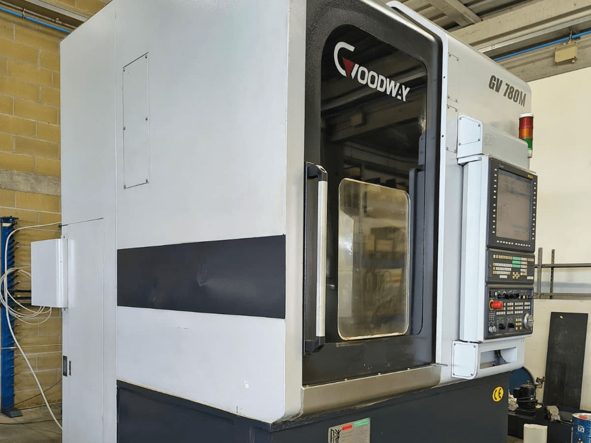 Tornio verticale Goodway GV 780 M, vista laterale, che mostra il pannello di controllo, le caratteristiche di sicurezza e il design esterno pulito.