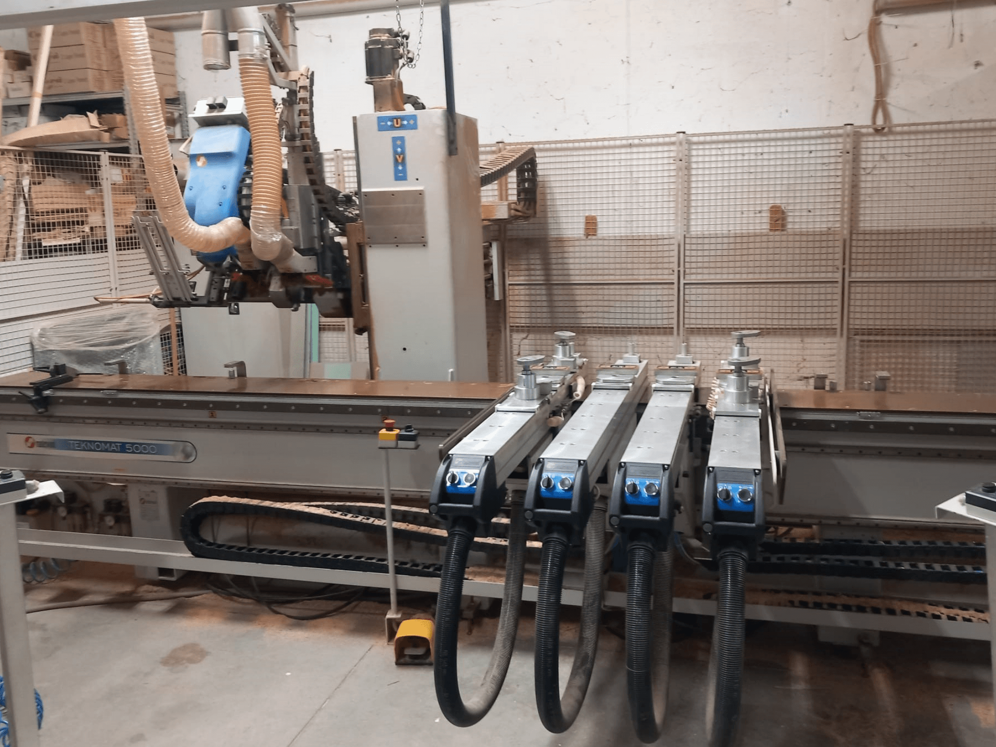 Centro di lavorazione del legno a controllo numerico MASTERWOOD TEKNOMAT 5000, vista frontale che mostra la testa utensile e i tubi di aspirazione multipli.