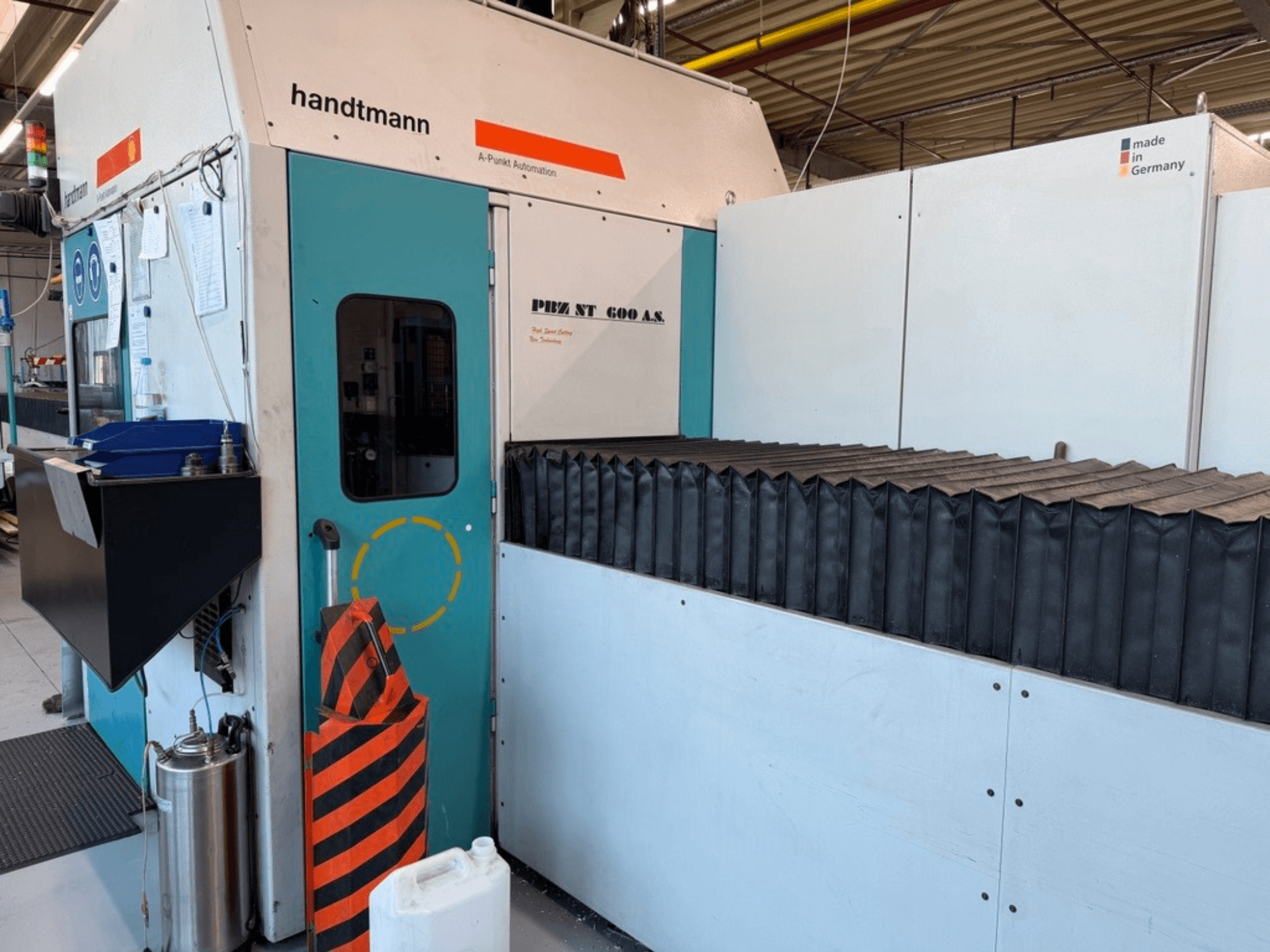 Vista frontale della fresatrice a portale Handtmann PBZ NT 600 AS, con superficie di lavoro scura e barriere di sicurezza.