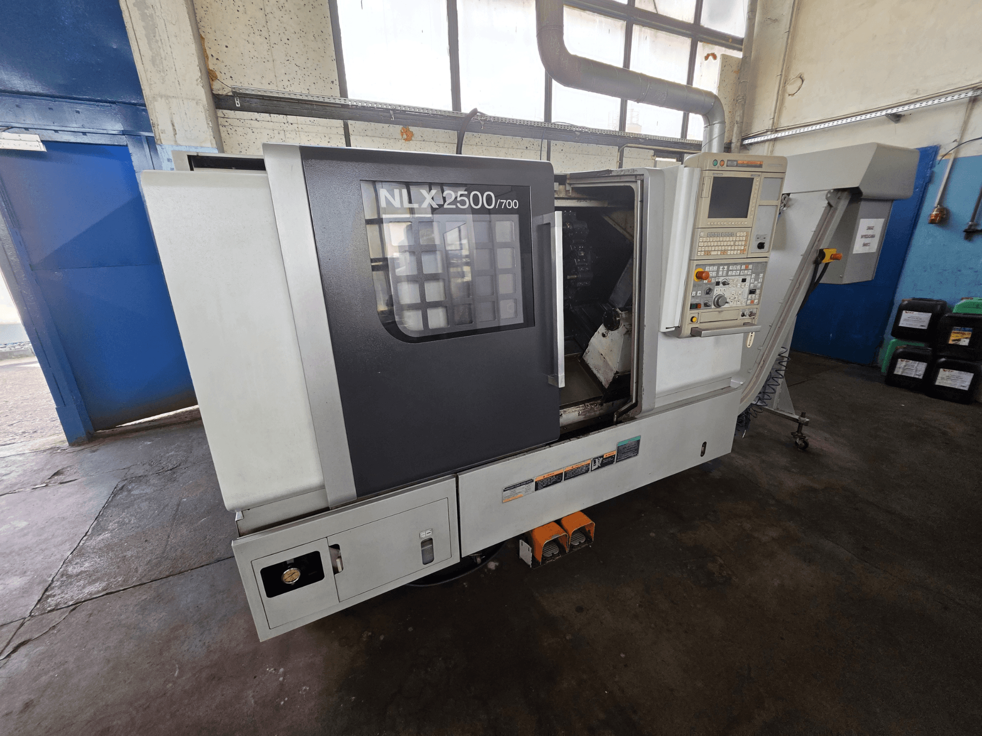 Tornio orizzontale DMG MORI NLX 2500/700 visto di lato, con pannello di comando e area di lavorazione visibile.