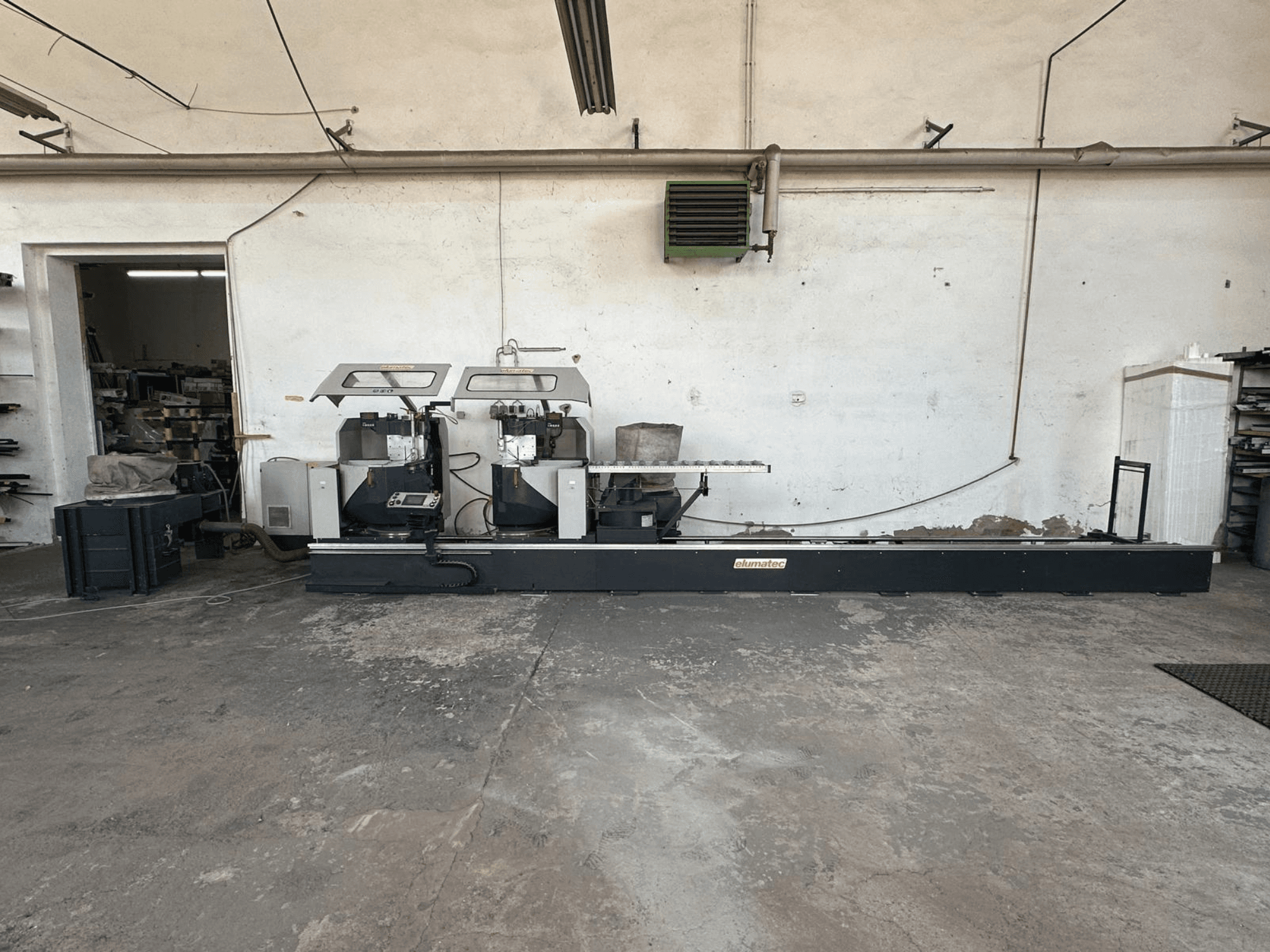 Sega circolare per metalli Elumatec DG 244 in un'officina, vista laterale che mostra la doppia sega e i comandi operativi su una base robusta.