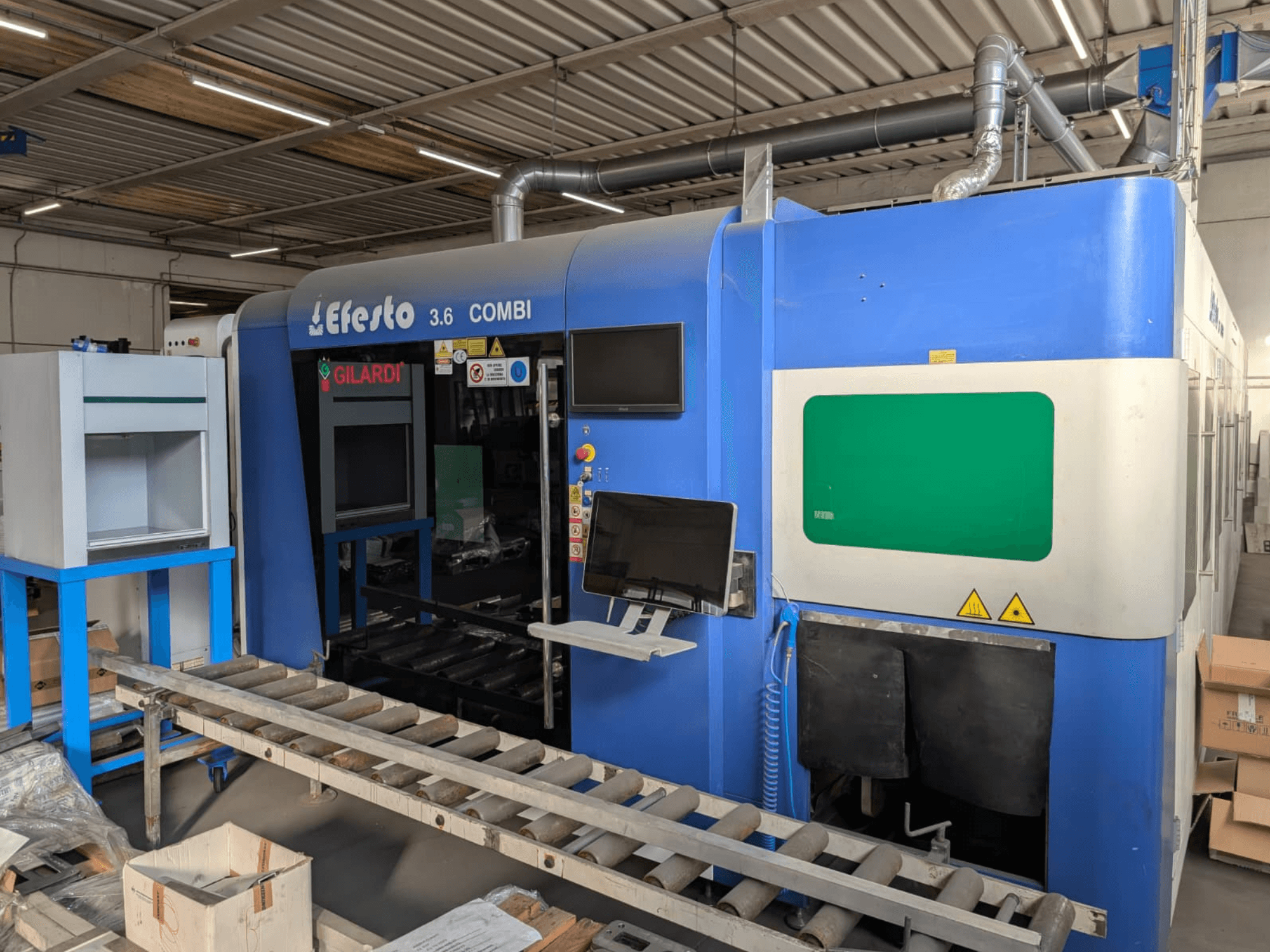 Macchina per il taglio laser a fibra EFESTO 3.6 COMBI, vista laterale, con pannello di controllo e indicatori di sicurezza, con struttura esterna di colore blu.
