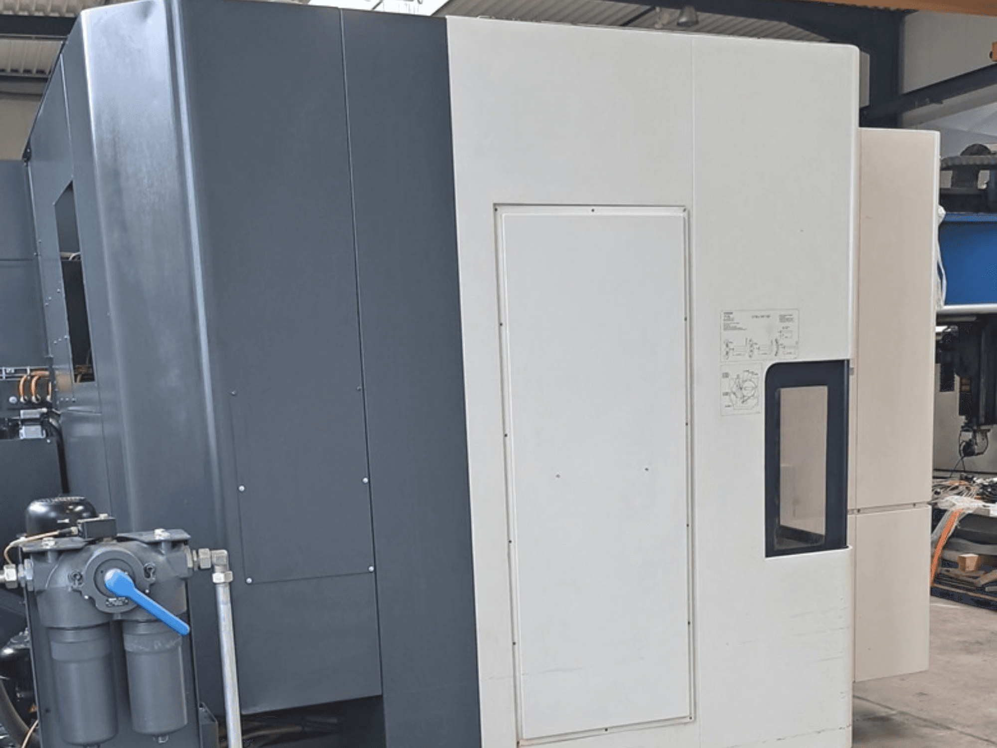 Centro di lavorazione orizzontale DMG MORI NHX5000, vista laterale che mostra il pannello di controllo e le caratteristiche meccaniche.