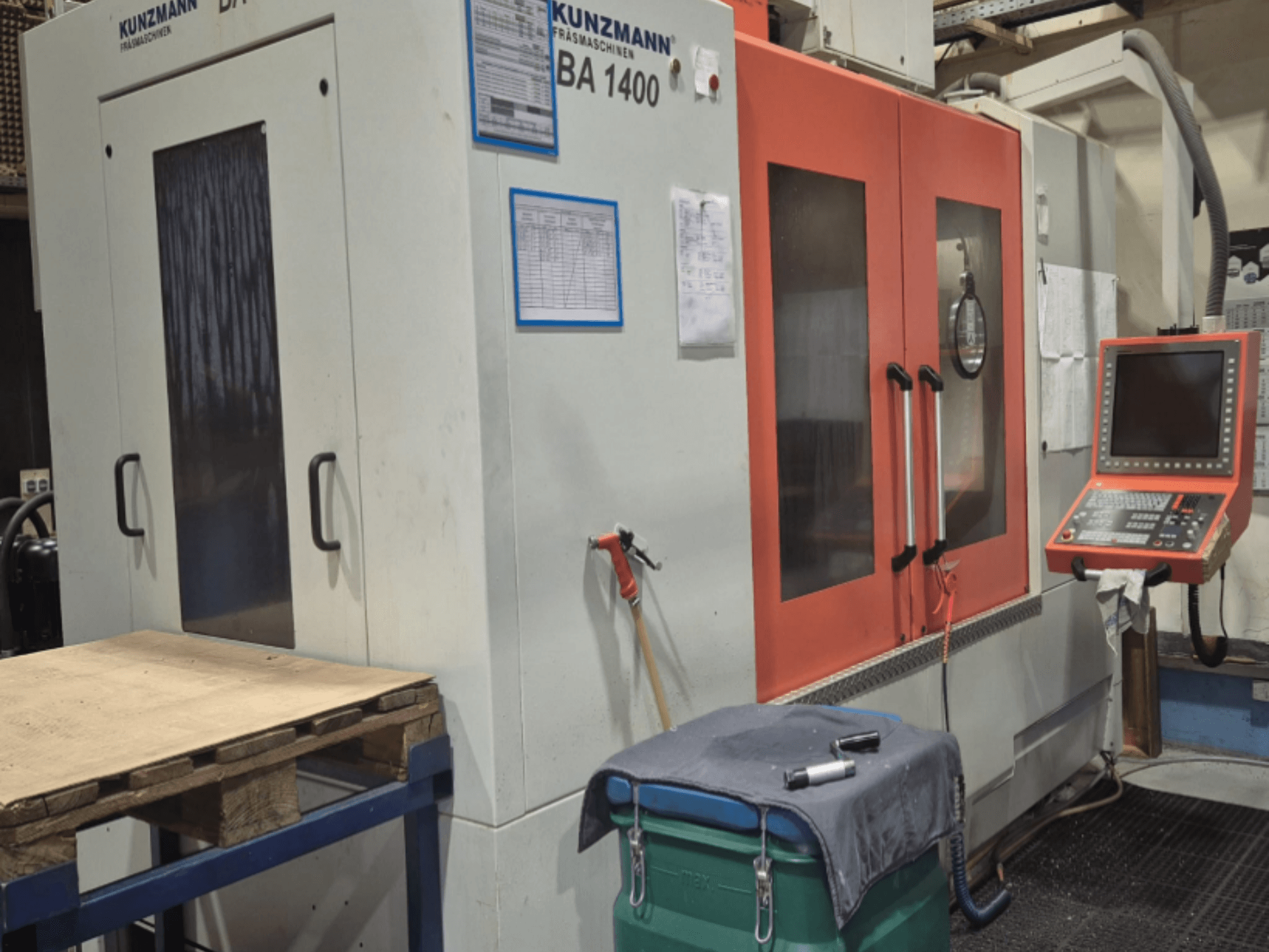 Centro di lavoro verticale KUNZMANN BA1400 vista frontale, con porte arancioni, pannello di controllo e piano di lavoro.