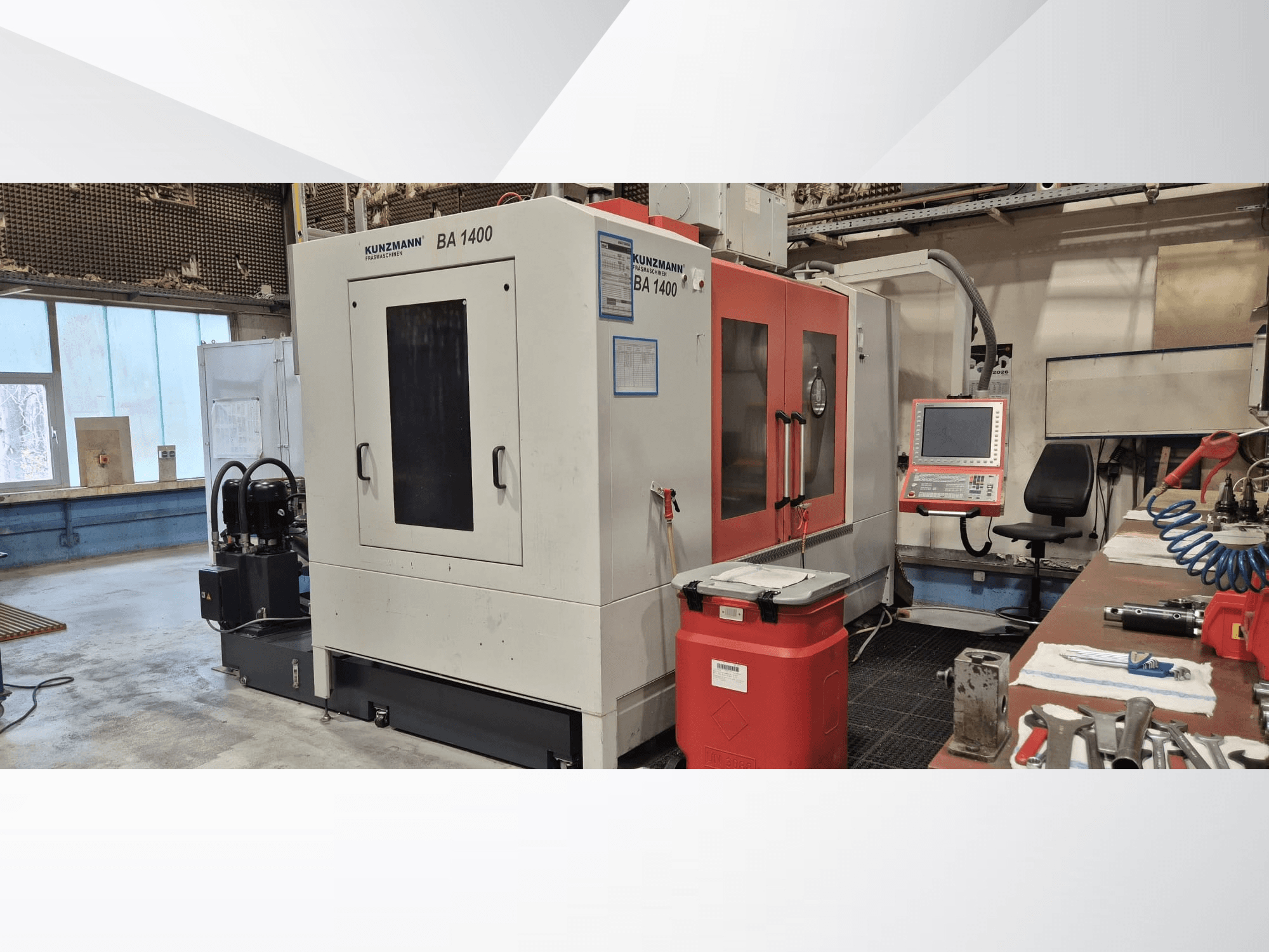 Centro di lavorazione verticale KUNZMANN BA1400 in un'officina, vista laterale che mostra il pannello di controllo e gli utensili circostanti.