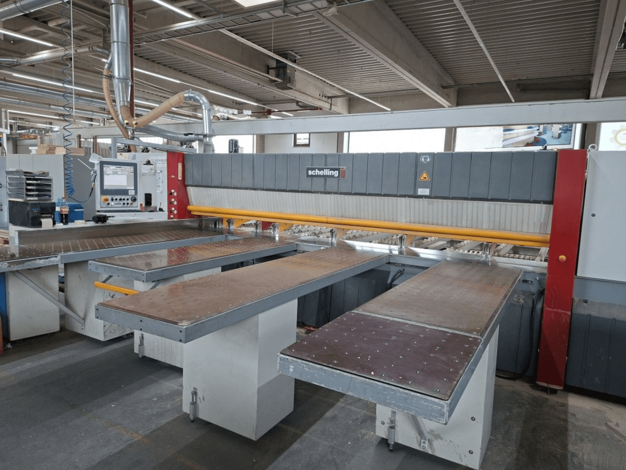 Sezionatrice SCHELLING FH 4 in officina, con doppio tavolo esteso e pannello di controllo. Vista frontale che evidenzia la configurazione operativa.