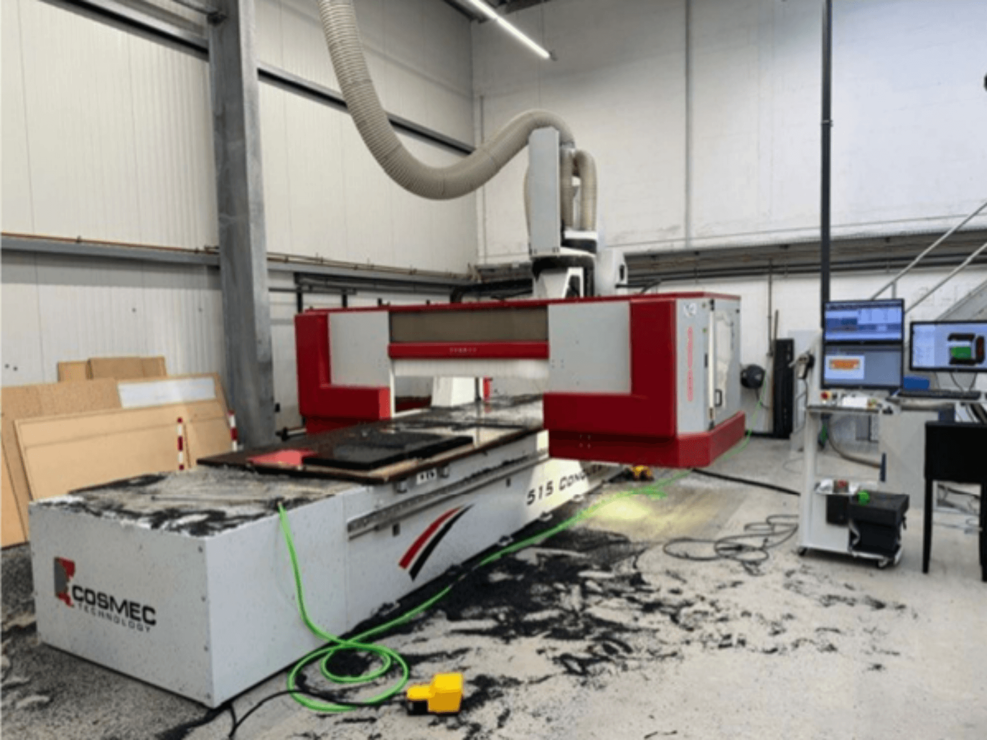 Macchina CNC Cosmec 515 in officina con terminale informatico, vista frontale e polvere sparsa sulla superficie.