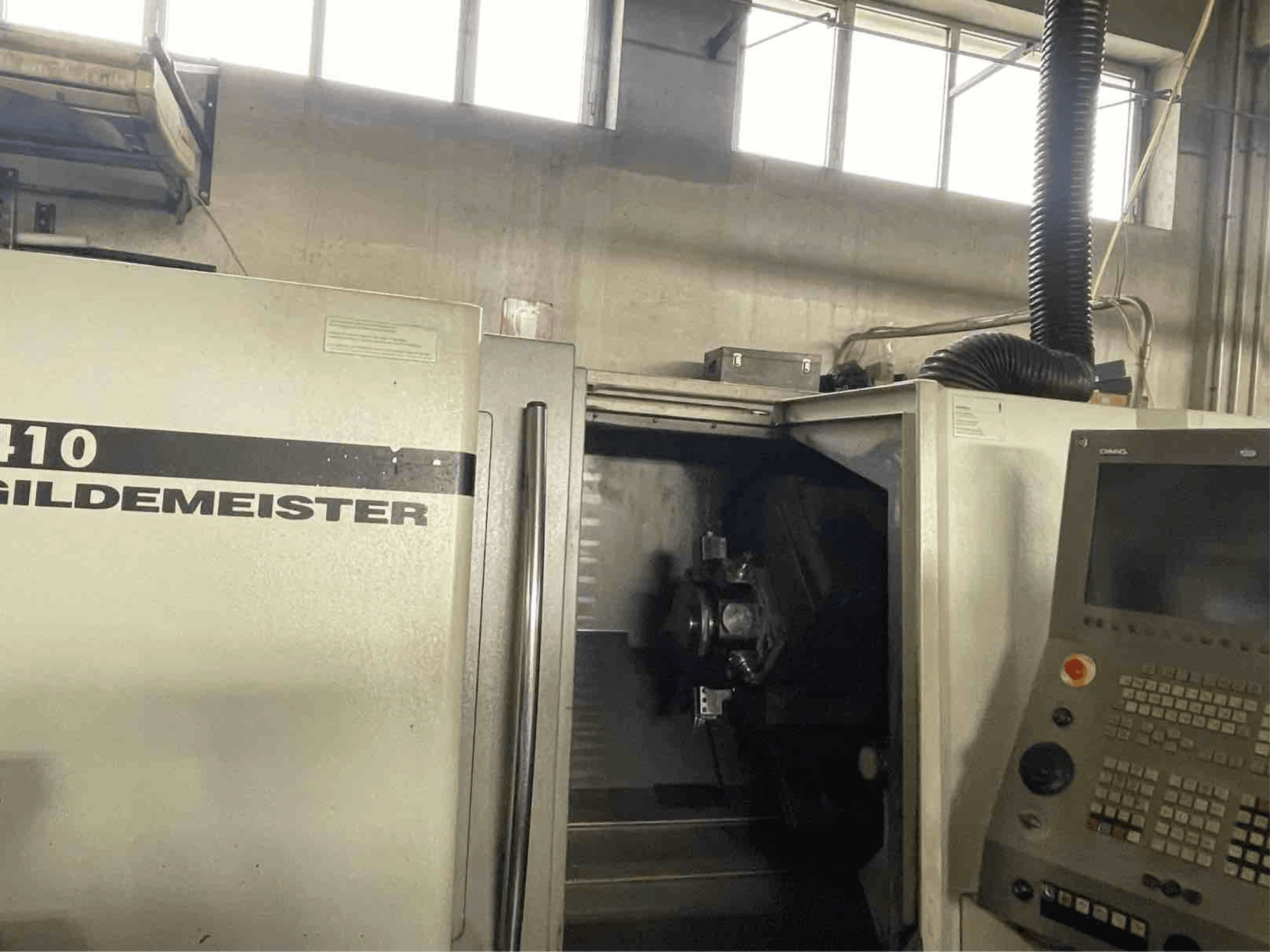 Tornio orizzontale DMG CTX410, vista frontale, con pannello di controllo e componenti di lavorazione visibili all'interno.