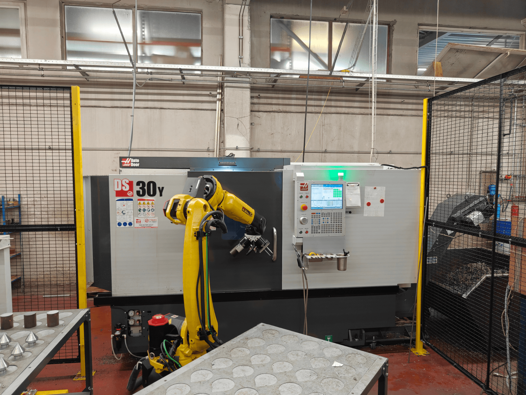Tornio orizzontale HAAS DS30Y con braccio robotico, vista frontale, con pannello di controllo e area di lavoro in primo piano.