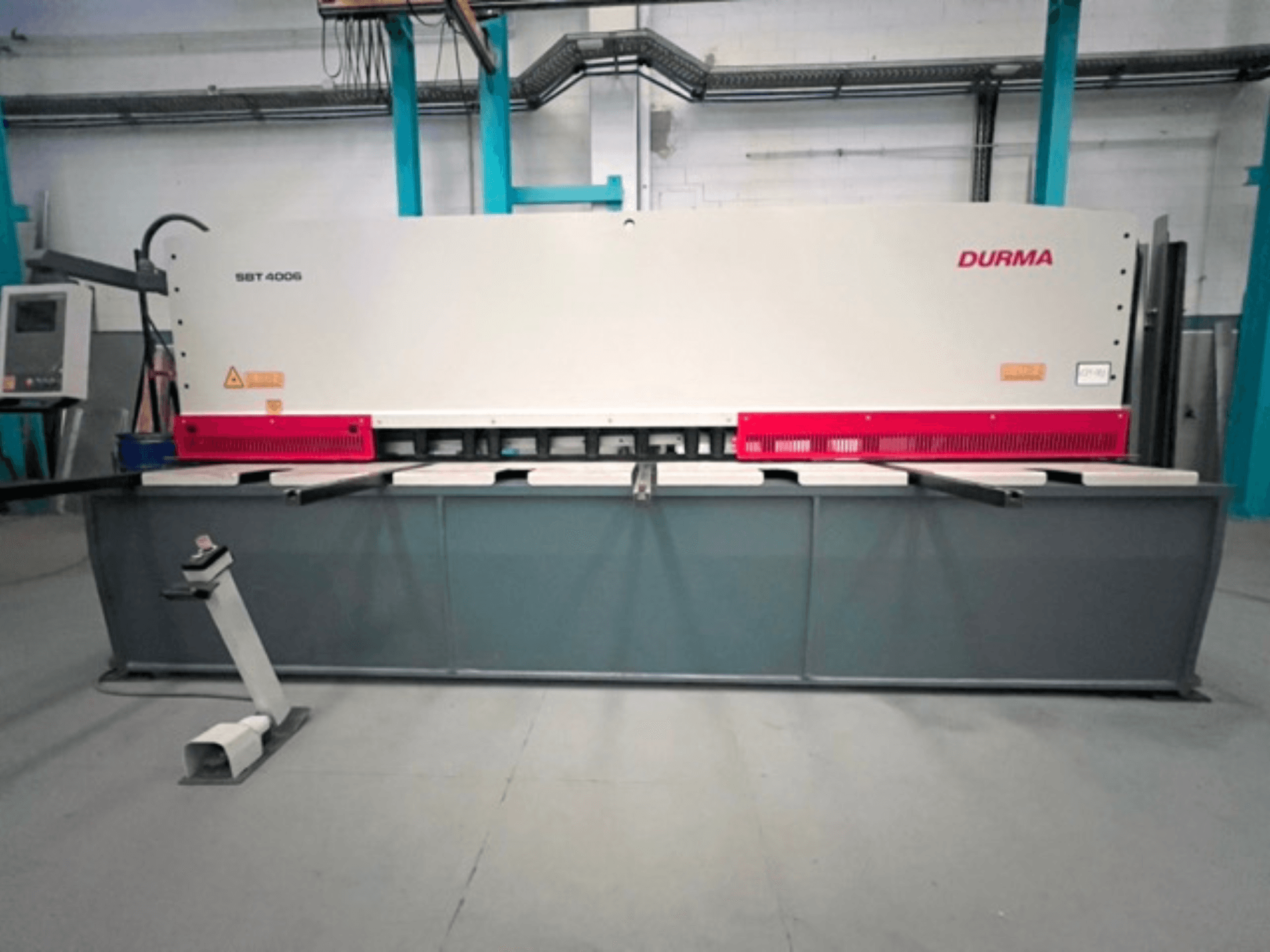 Cesoia CNC Durma SBT 4006 in vista frontale, con base grigia e accenti rossi, pronta per il funzionamento in fabbrica.