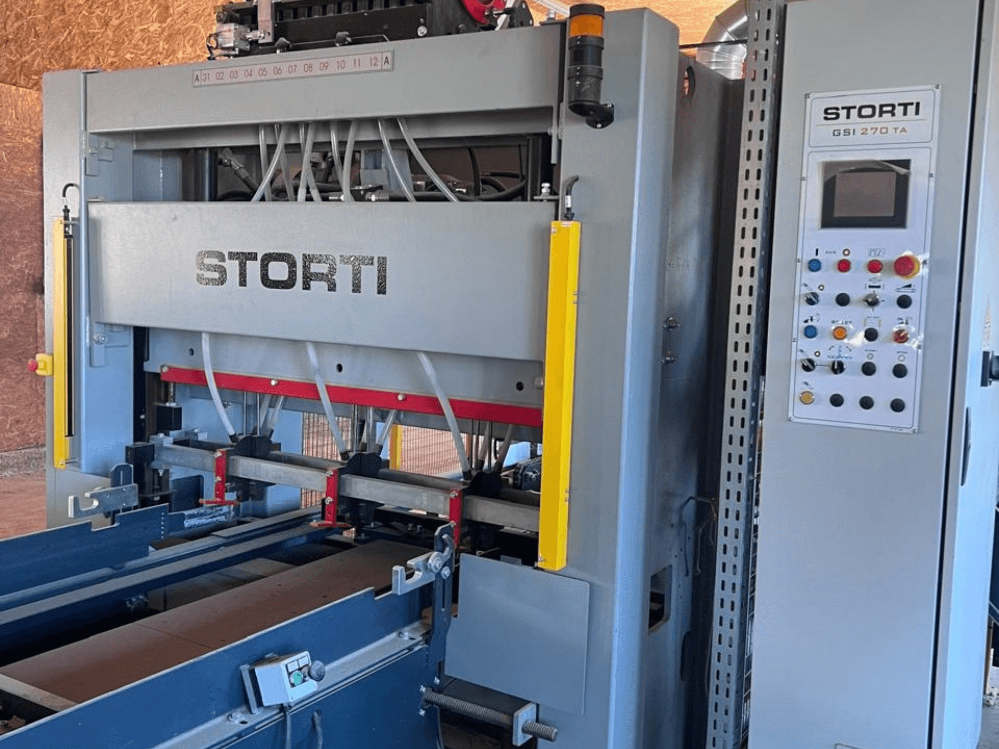 Linea di lavorazione del legno STORTI GSI 170-270 TA9, vista frontale che mostra il pannello di controllo e i meccanismi della pressa idraulica.