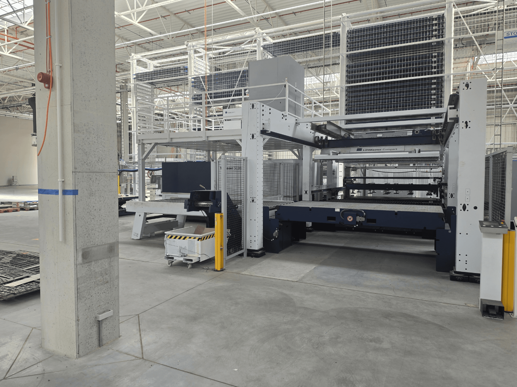 Vista frontale della TRUMPF TruLaser 5030 fiber L76 FMC, che mostra la macchina per il taglio laser a fibra ottica in un ampio ambiente industriale.