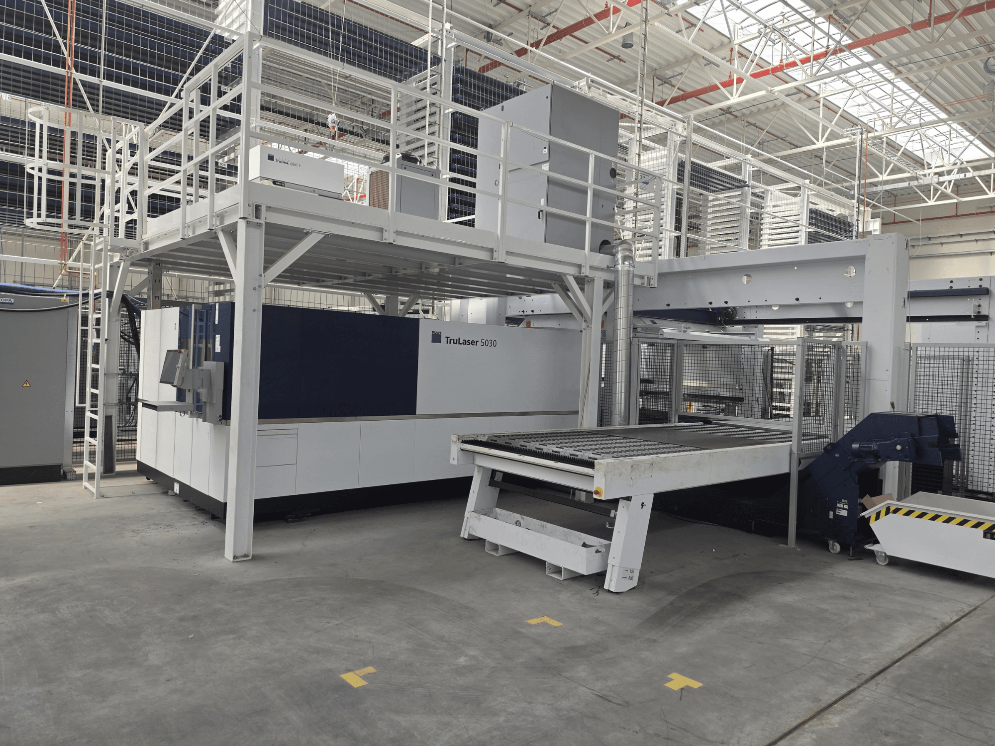 Macchina TRUMPF TruLaser 5030 fiber L76 FMC in un'officina, vista frontale che mostra l'area di taglio e il meccanismo di carico/scarico.