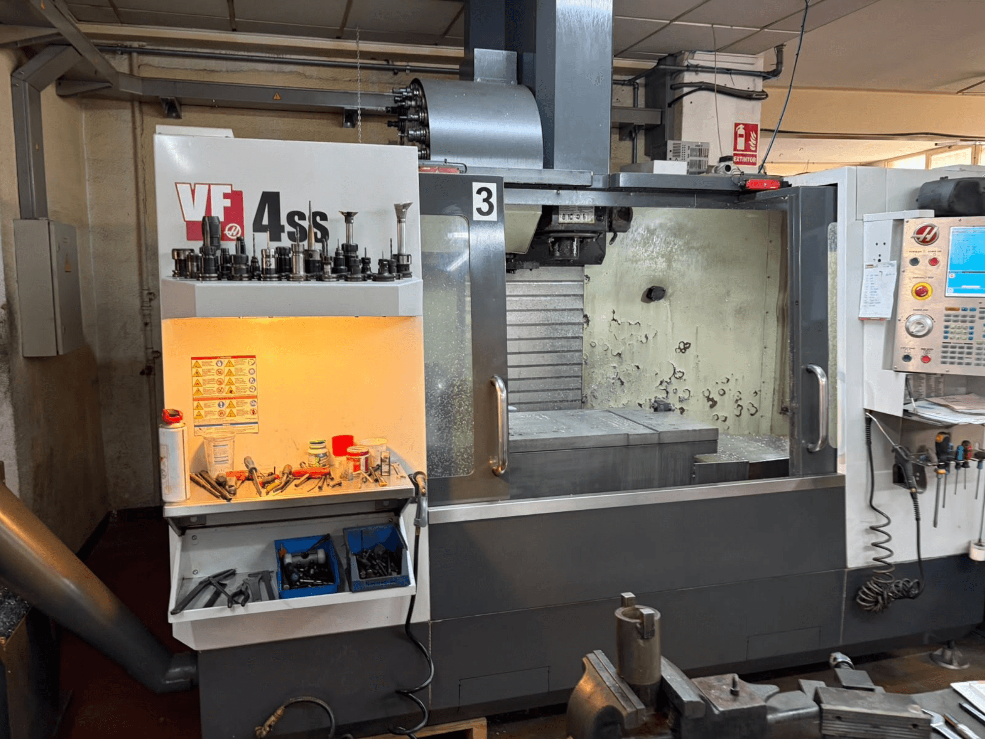 Centro di lavorazione verticale HAAS VP 4SS, vista frontale, con magazzino utensili, pannello di controllo e area di lavoro visibile con dettagli della lavorazione.