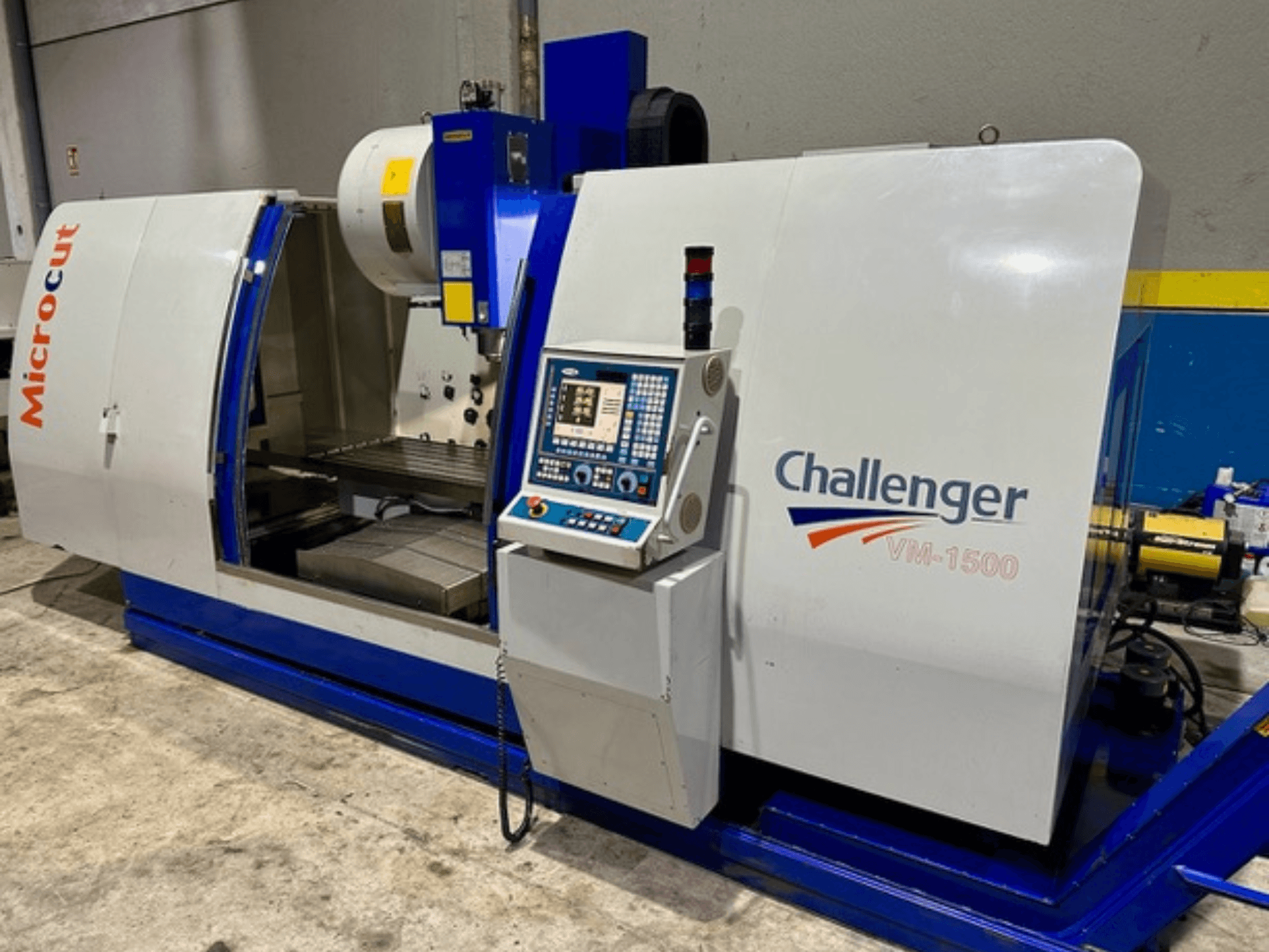 Macchina CNC Microcut Challenger VM-1500, vista frontale, con pannello di controllo, area di lavoro e base blu.