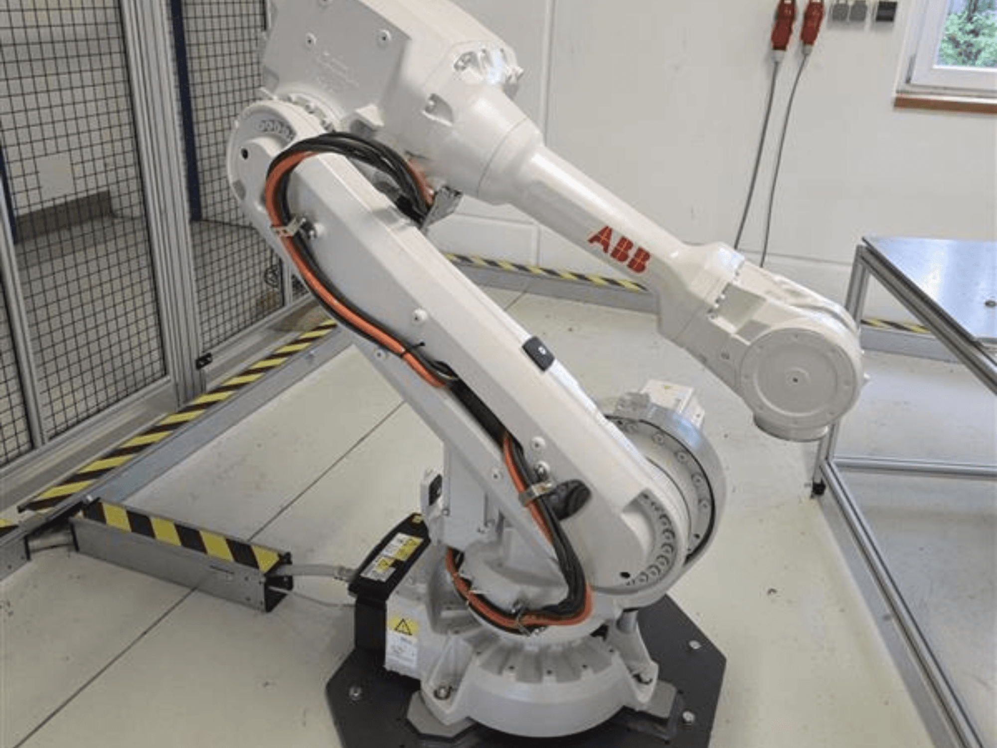 Braccio robotico ABB IRB 4600-45/2.05 visto di profilo, che ne evidenzia il design articolato e i cavi collegati alla base.
