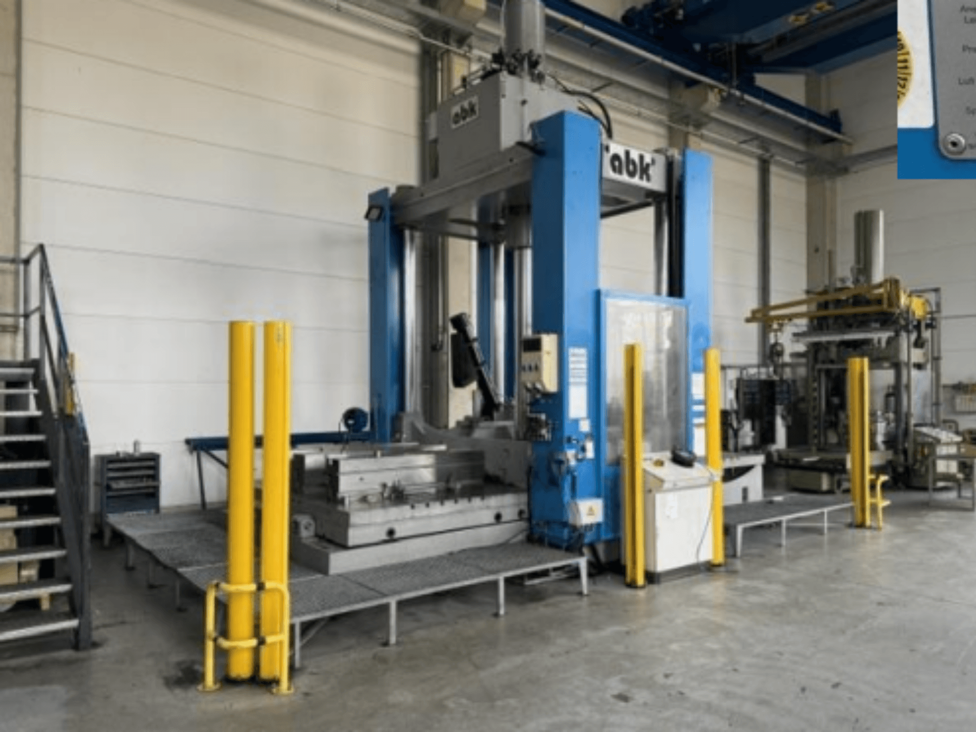 Macchina utensile ABK abk-TP-20-250 vista frontale, con barriere di sicurezza di colore giallo e attrezzature di lavorazione circostanti.