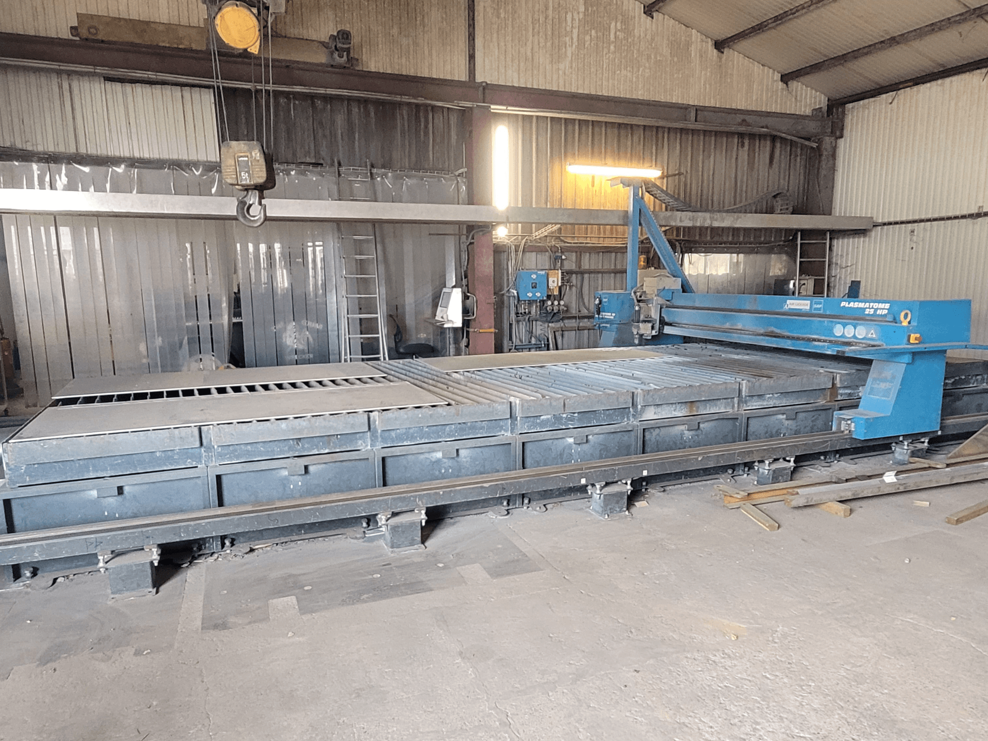 Macchina di taglio al plasma SAF Plasmatone 25Hp, vista laterale, che mostra il banco di taglio e i componenti operativi in un ambiente industriale.