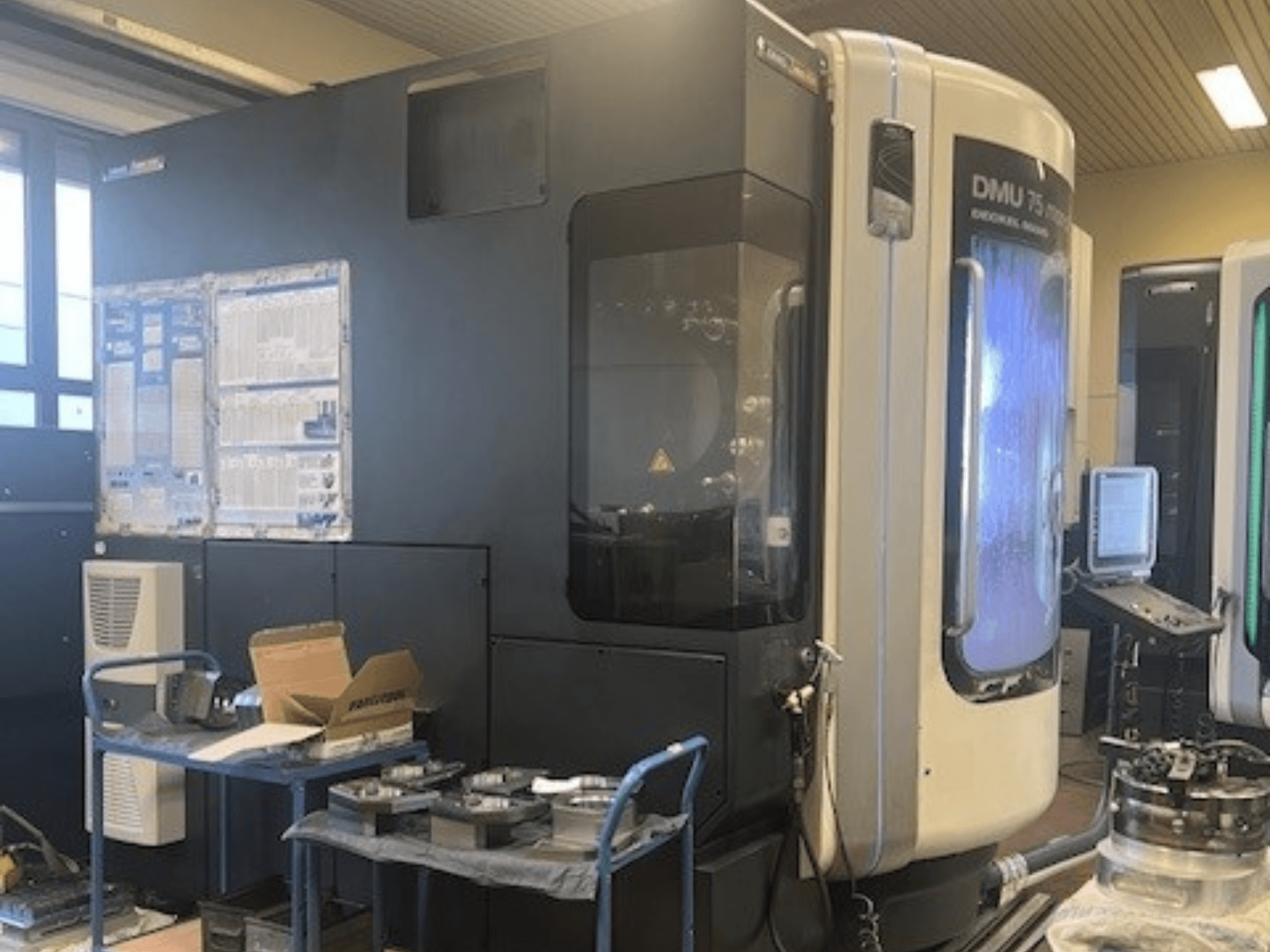 Centro di lavoro universale DMG Mori Seiki DMU 75 monoBlock, vista frontale, che mostra il pannello di controllo, il sistema di raffreddamento e l'area di lavoro.