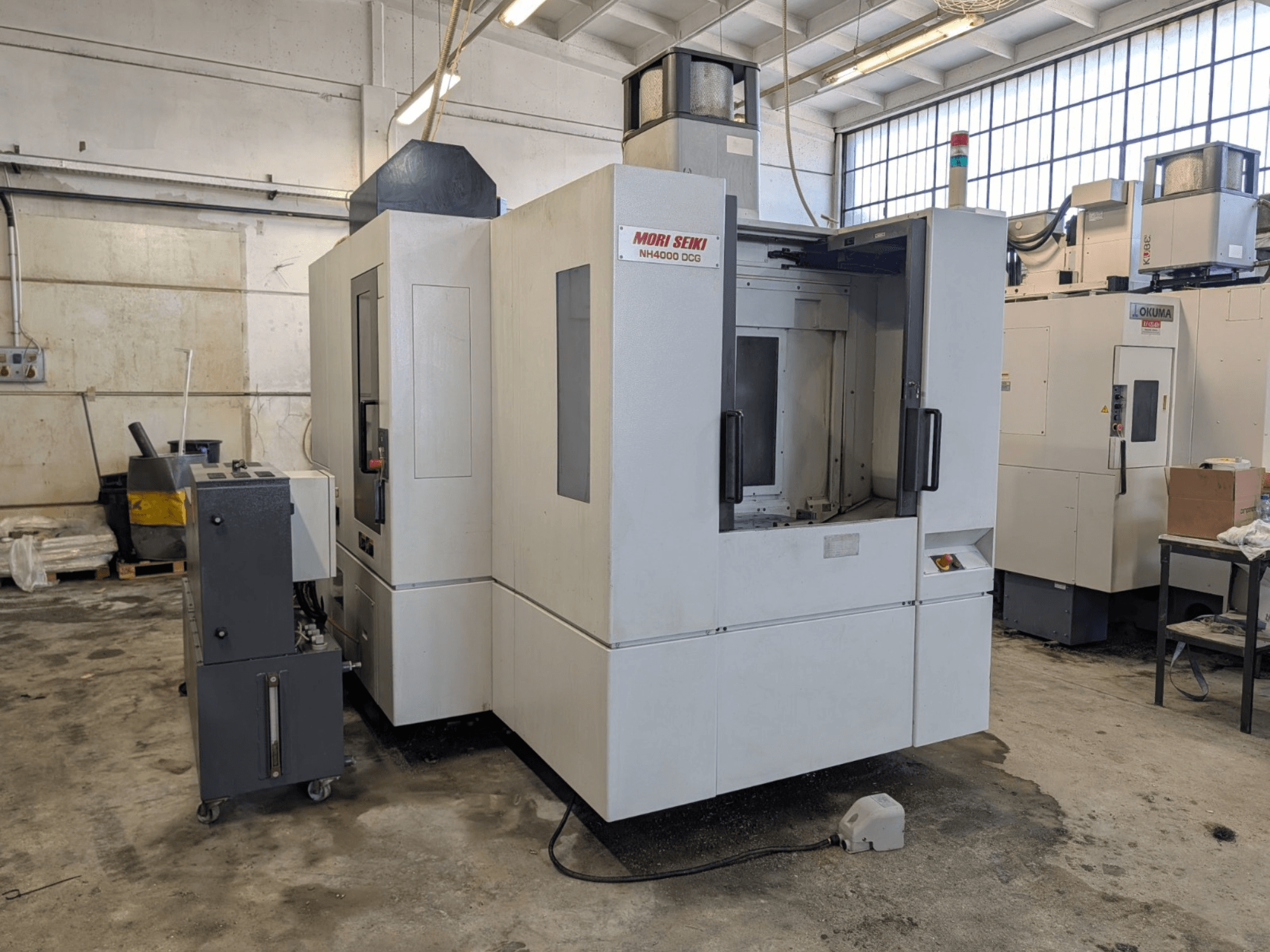 Centro di lavoro orizzontale MORI SEIKI NH 4000 DCG, vista frontale, pannello di controllo e area di lavoro, finitura grigia e bianca.
