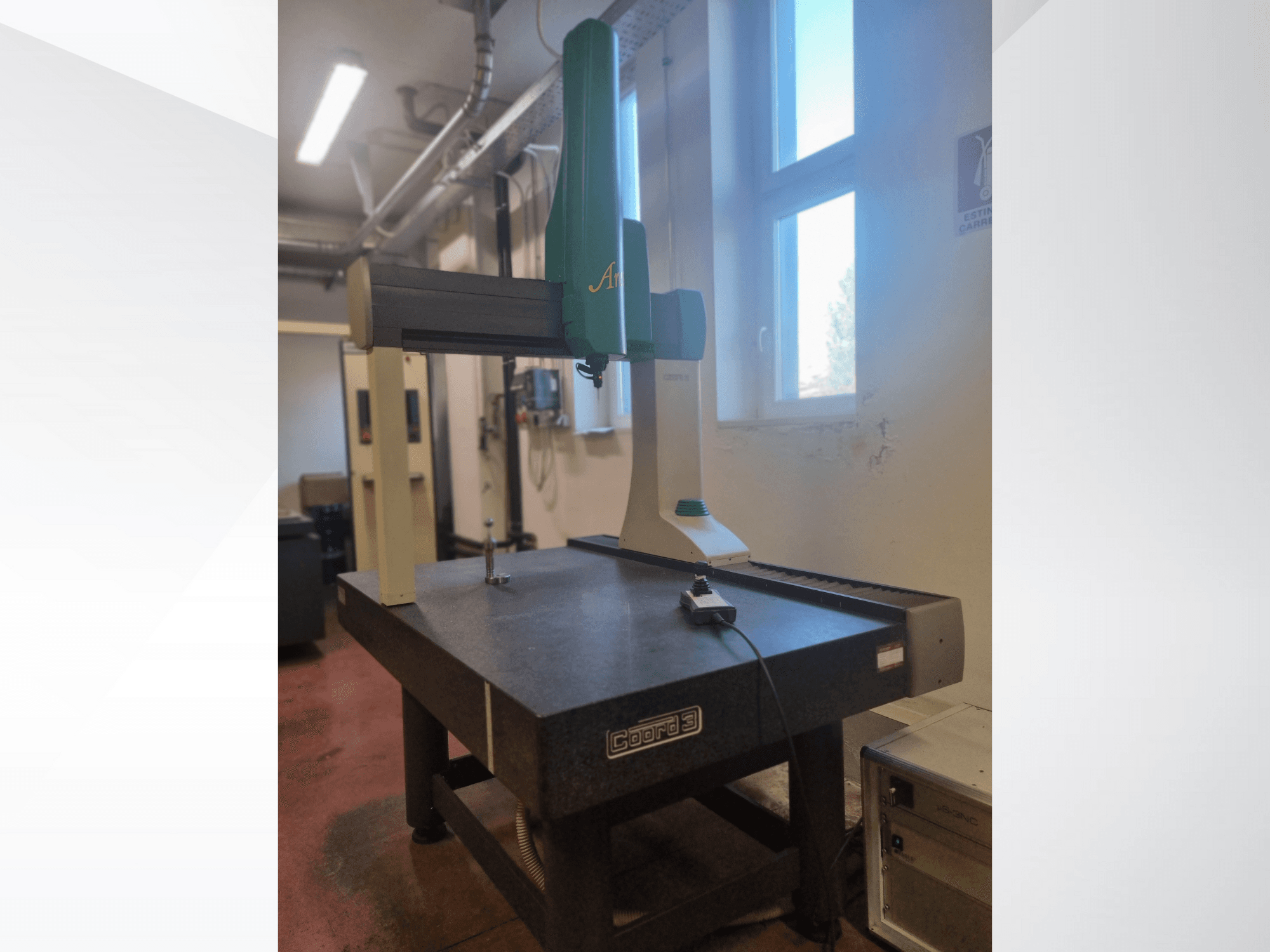 Scanner 3D GOM Atos visto frontalmente su un tavolo di misurazione in granito, con cavo e dispositivo di controllo visibili.