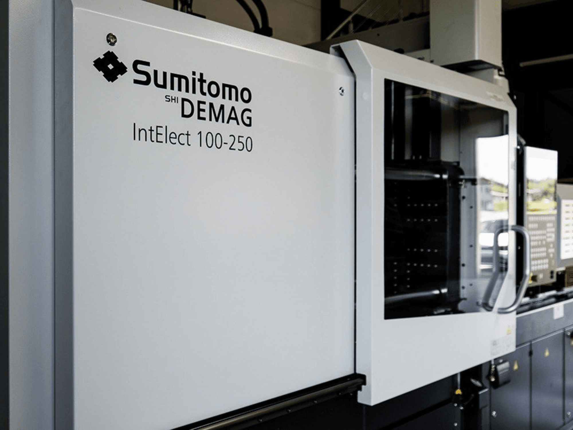 Vista frontale della pressa a iniezione elettrica SUMITOMO SHI DEMAG IntElect 100/250 con pannello di controllo e dispositivi di sicurezza.