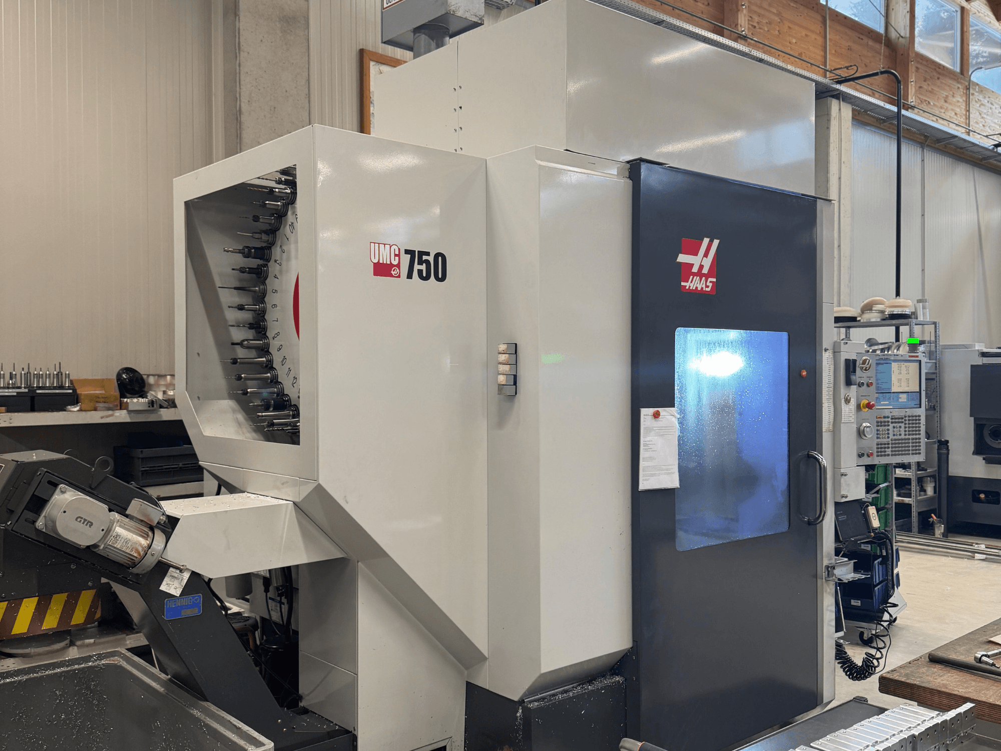 Centro di lavoro Haas UMC 750, vista frontale, che mostra il portautensili e il pannello di controllo in un'officina.