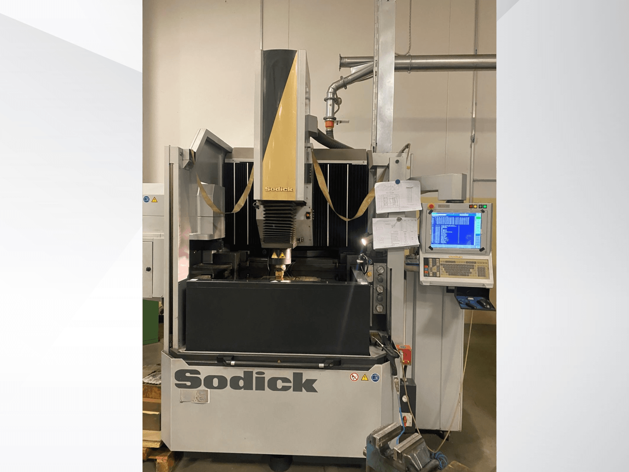 Macchina per elettroerosione Sodick in vista frontale, con pannello di controllo, tavolo di lavoro e testa di taglio sopraelevata.