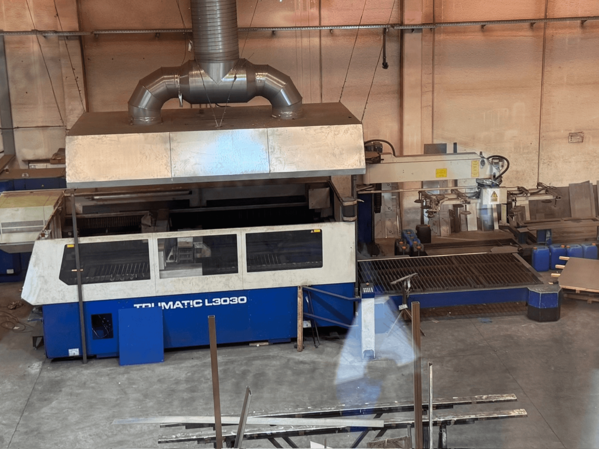 Macchina per il taglio laser a CO₂ TRUMPF TRUMATIC L3030 in un'officina, vista frontale che mostra il pannello di controllo e il piano di taglio.