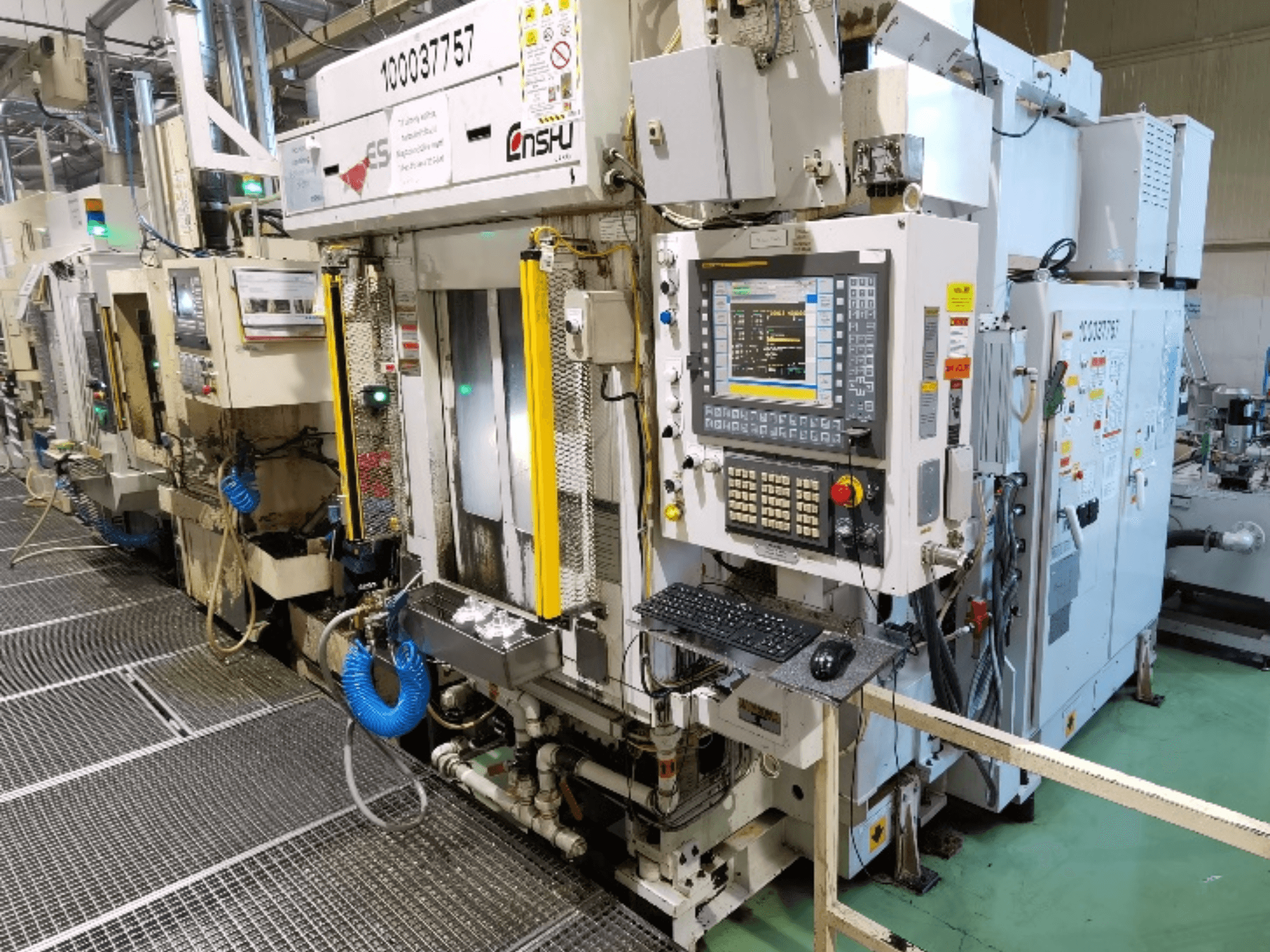 Testo alternativo: Vista frontale del centro di lavoro verticale Enshu ES400, con pannello di controllo, tastiera e componenti della macchina in primo piano.