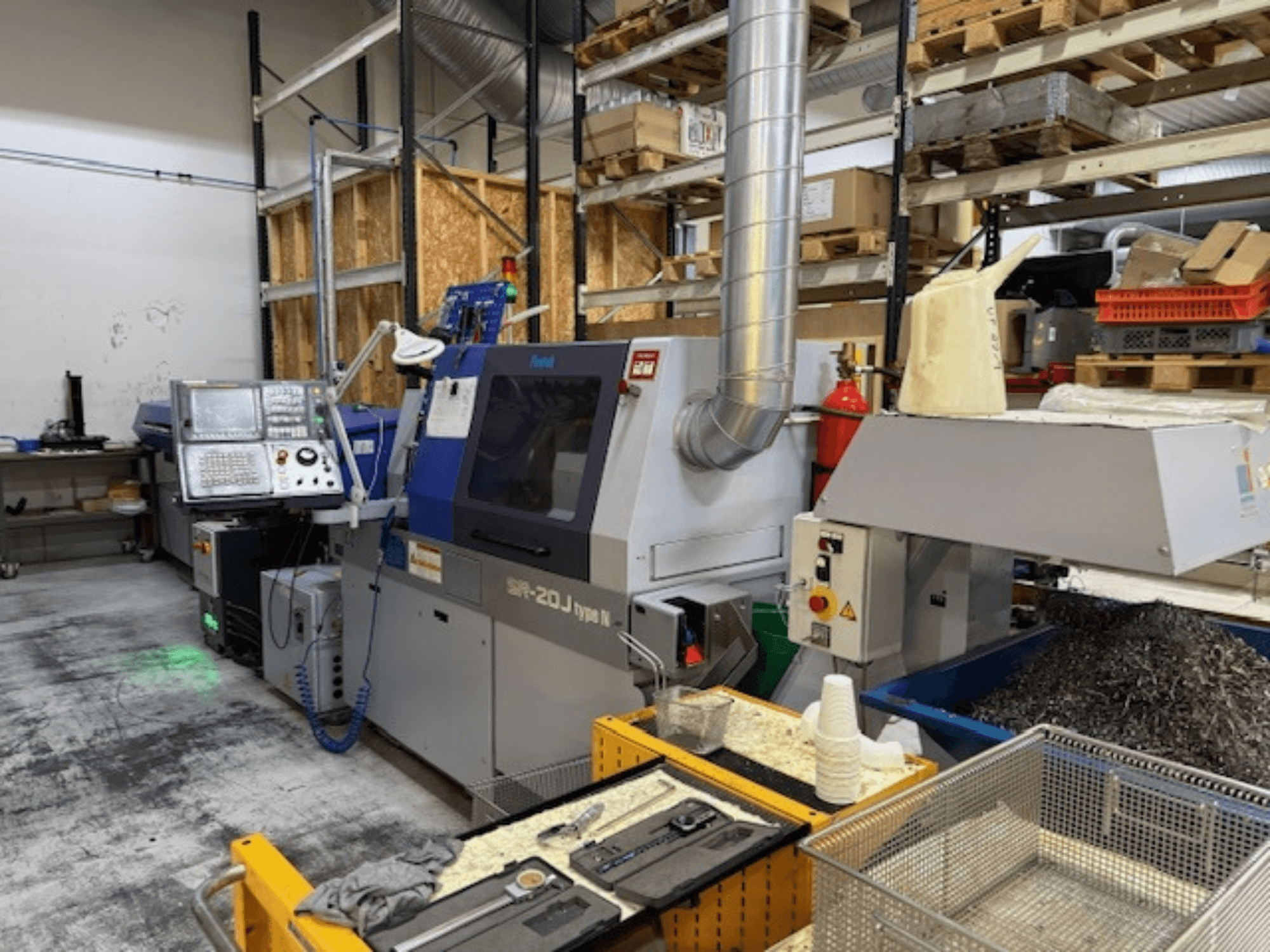 Vista frontale di un centro di lavoro Faroh SPR-20J di tipo N con pannello di controllo, trucioli di metallo e dispositivi di sicurezza in un'officina.