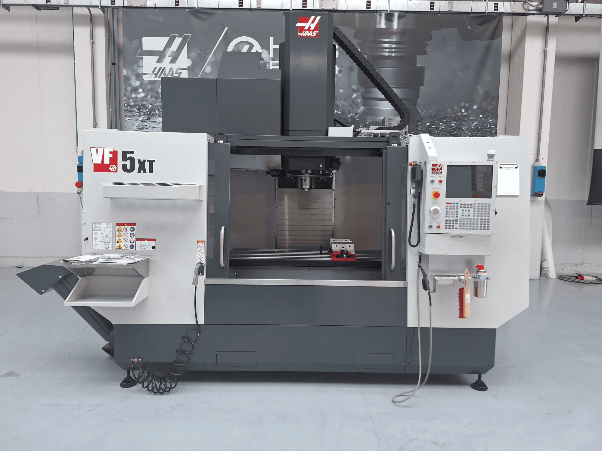Centro di lavorazione verticale HAAS VF-5/50XT, vista frontale, con pannello di controllo, zona mandrino e magazzino utensili.
