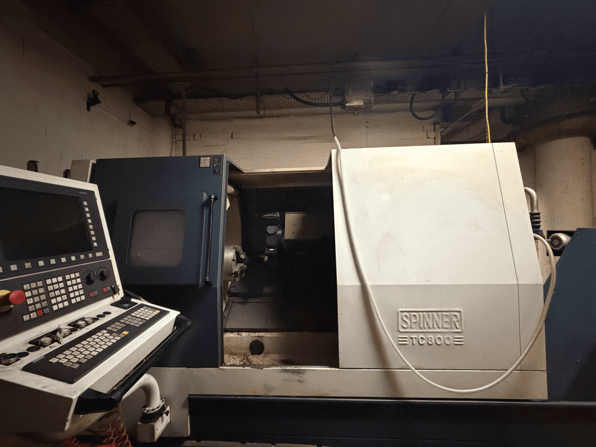 Tornio orizzontale SPINNER TC800, vista frontale con pannello di controllo visibile e interno macchina leggermente esposto.
