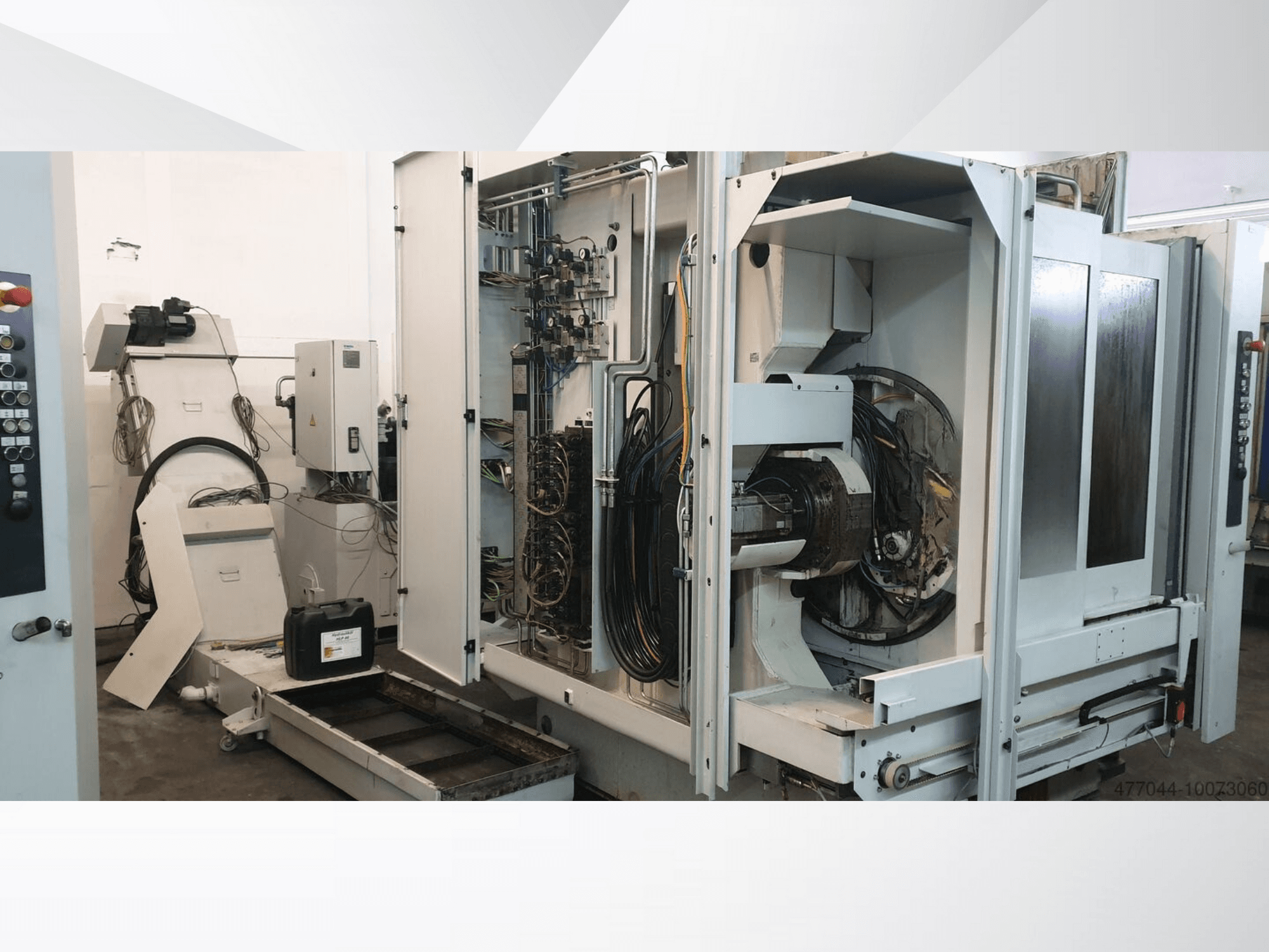 Macchinario industriale con cablaggio a vista, pannello di controllo e componenti meccanici; vista laterale di una macchina complessa.