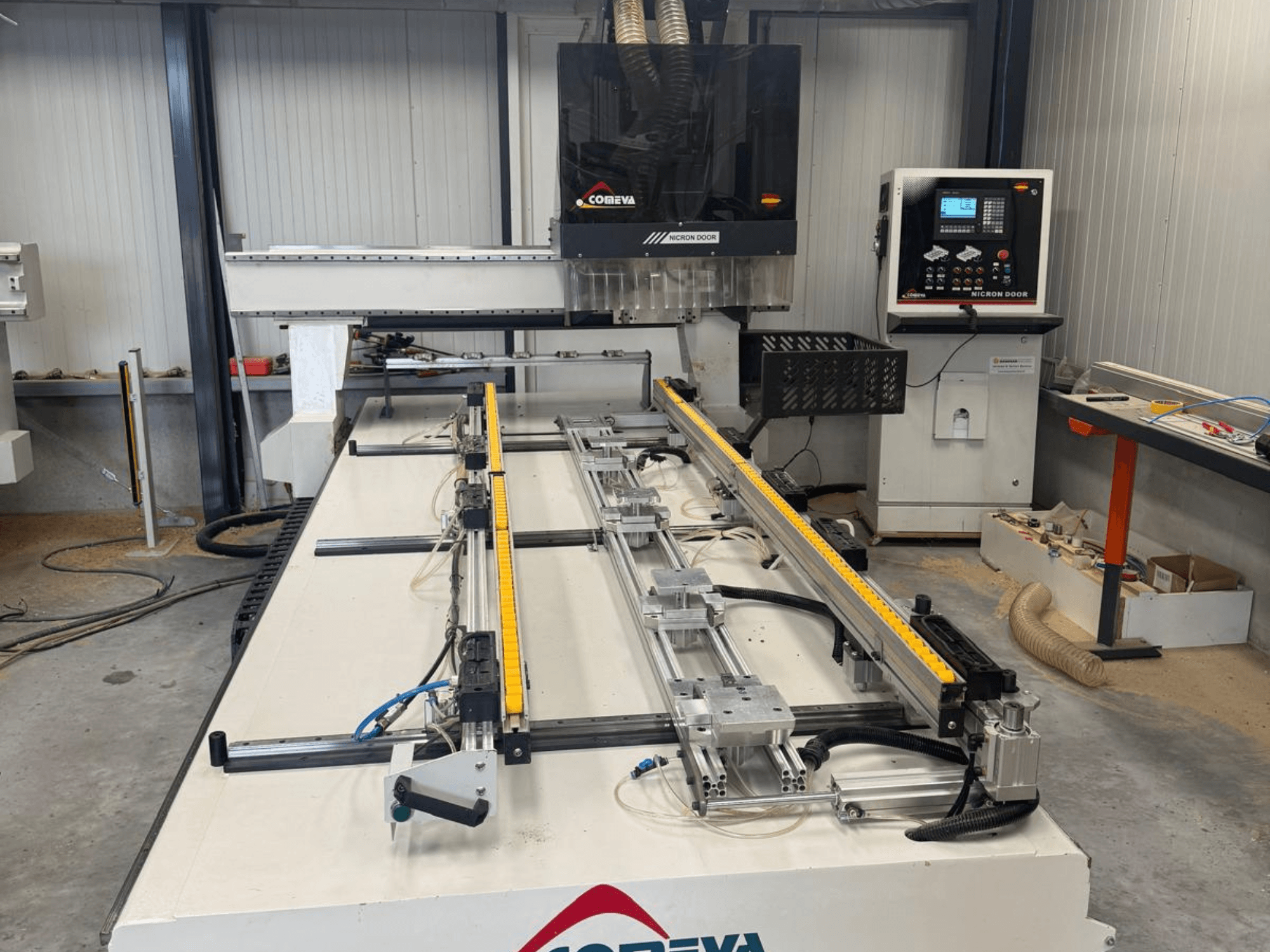 Centro di lavorazione del legno a controllo numerico COMEVA MEX V 2100x3260, vista frontale, con postazione di lavoro, pannello di controllo e guide.