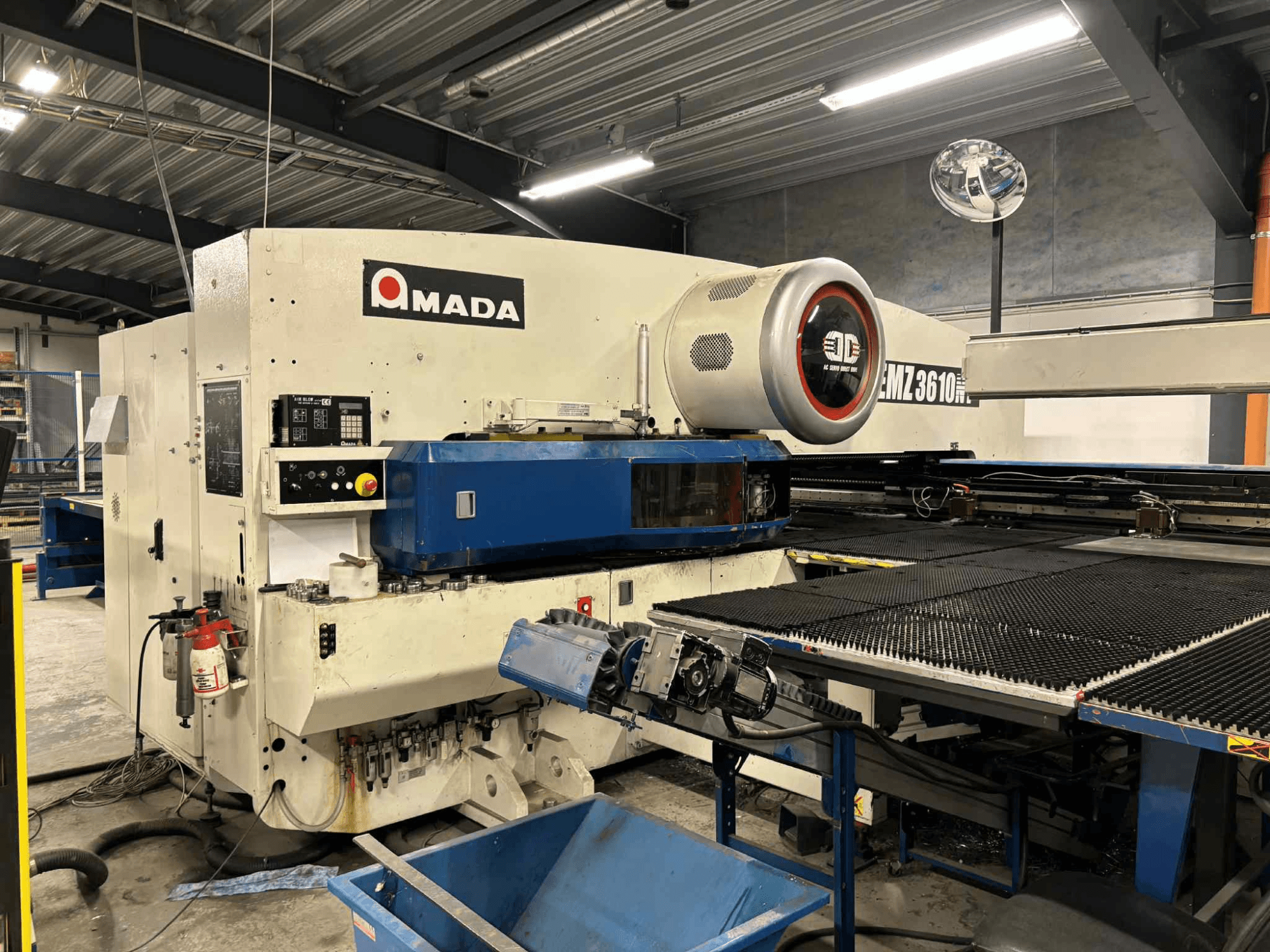 Punzonatrice Amada EMZ3610H vista dal davanti; presenta comandi operativi, pianale blu e dispositivi di sicurezza.