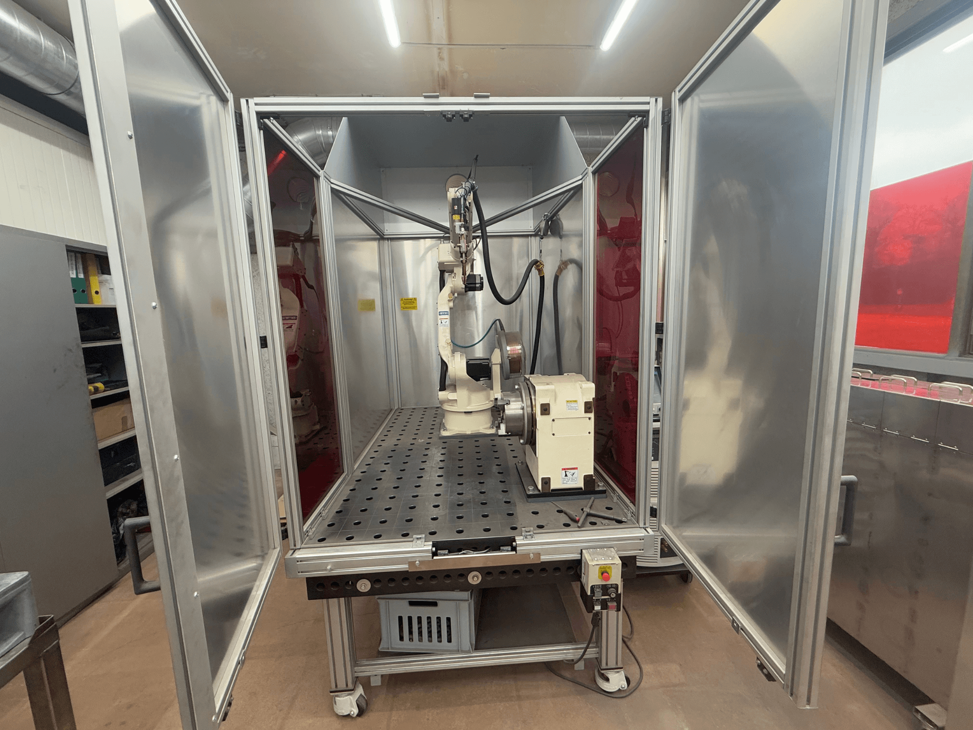 Robot di saldatura OTC Daihen EASY ARC V02.04 in un involucro metallico, visto frontalmente, con braccio articolato e pannello di controllo.