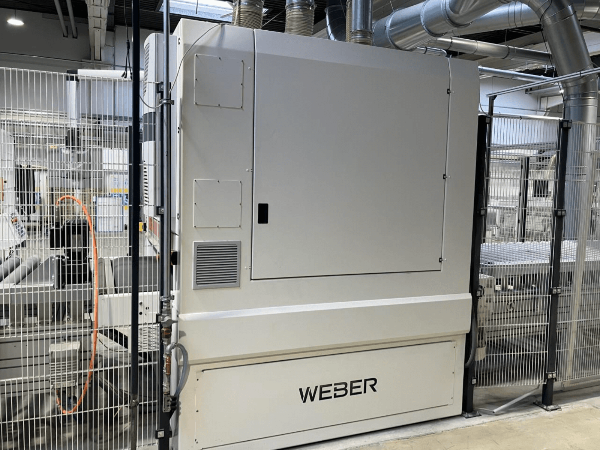 Vista frontale della linea di produzione di legno HYMMEN JUPITER JPT C 680/548, con il componente WEBDER e la recinzione di sicurezza visibile.