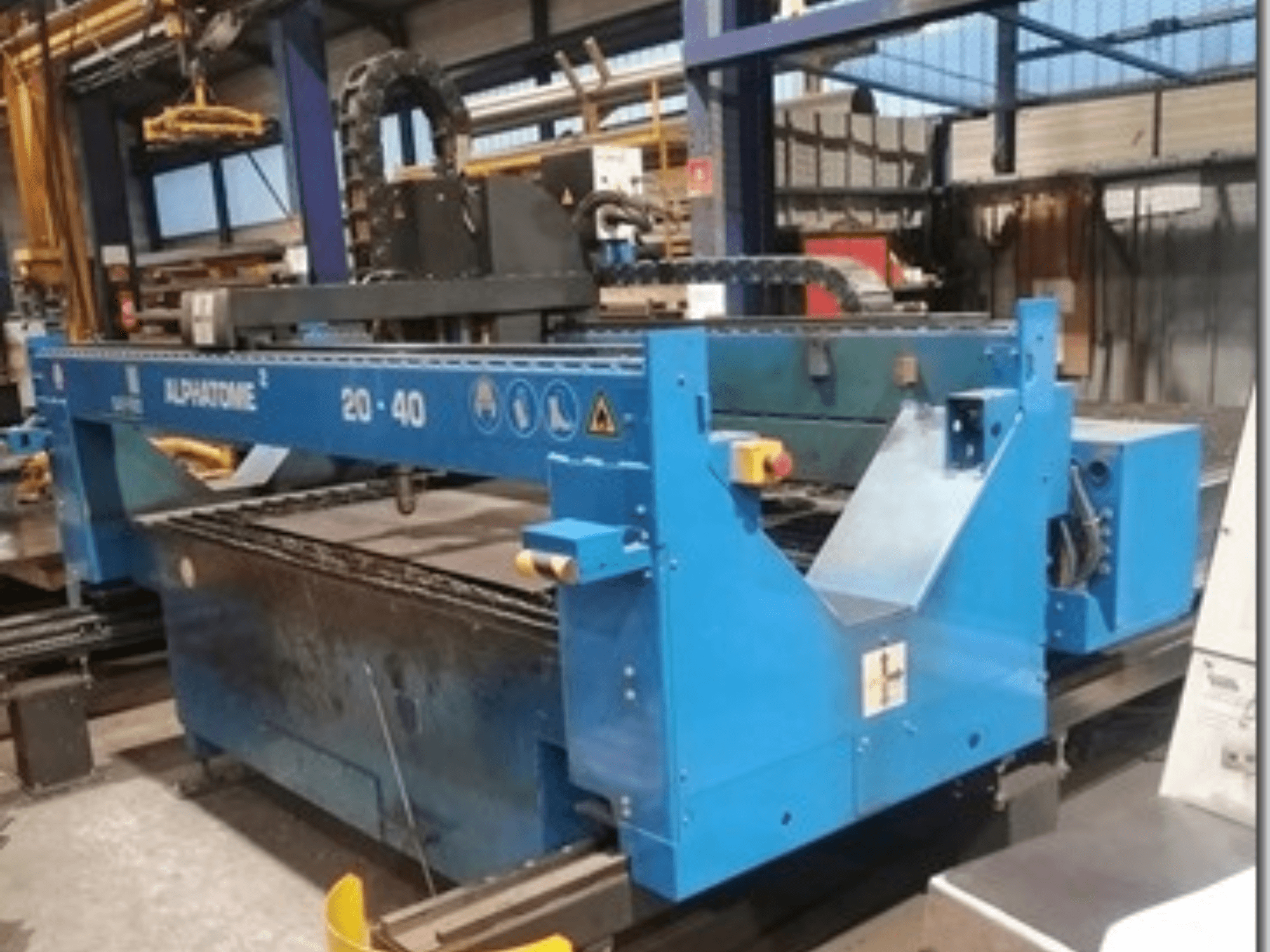 Macchina CNC ALPHATOME 20-40 blu, vista frontale, con area di taglio e pannello di controllo visibili, progettata per la produzione di precisione.