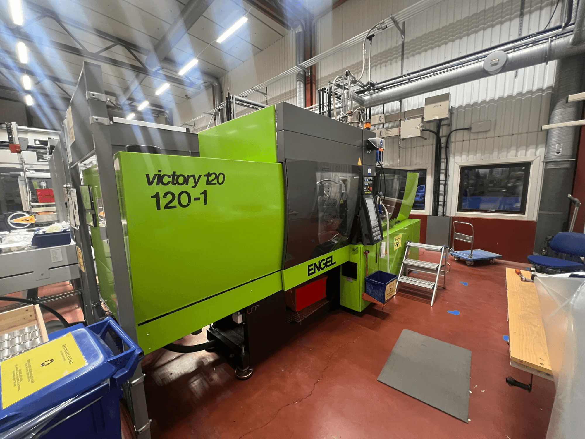 Macchina ad iniezione ENGEL Victory 120-1 verde, vista frontale, con pannello di controllo e gradini, in un ambiente industriale.