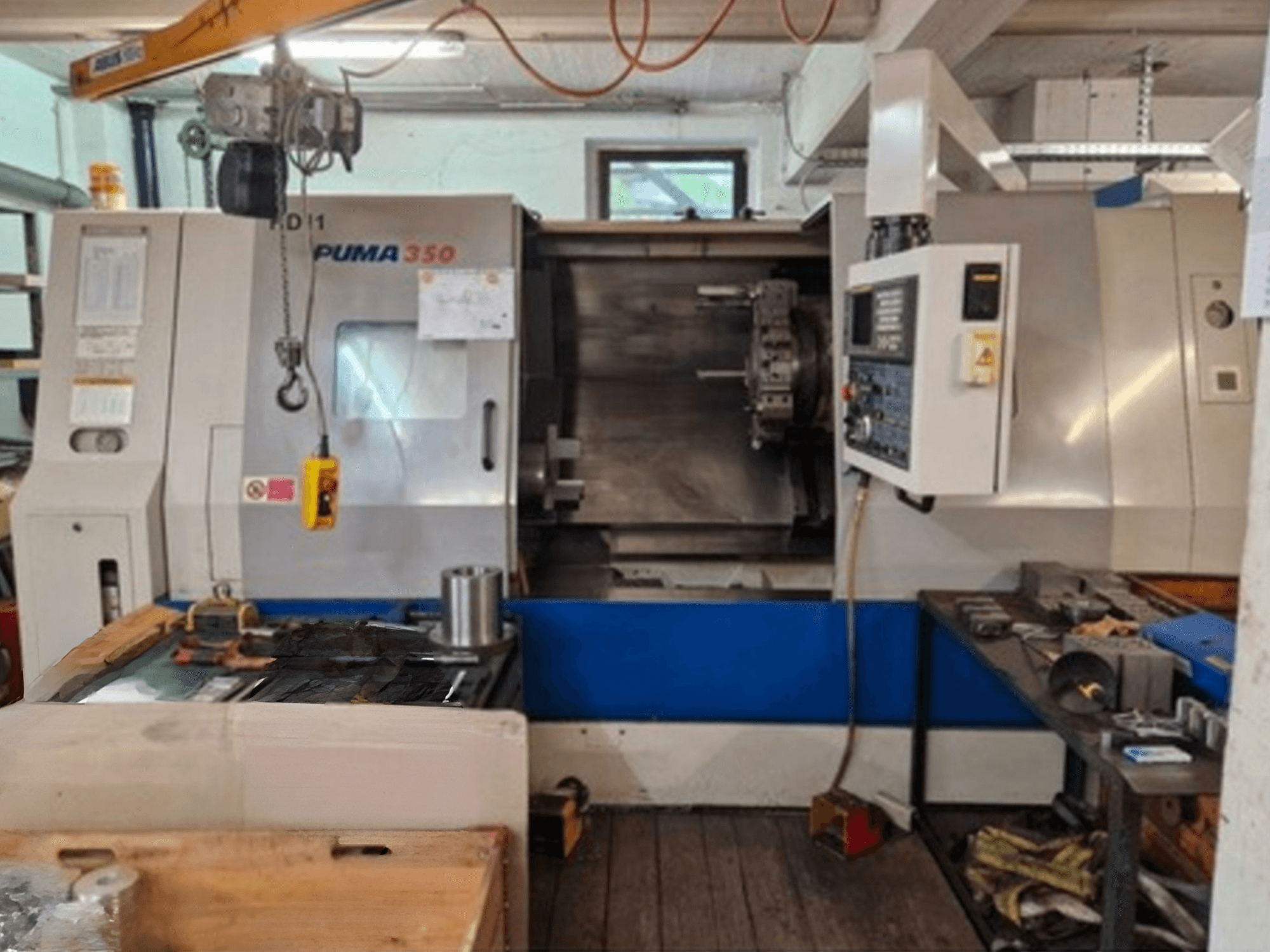 Tornio orizzontale DAEWOO Puma 350, vista laterale, che mostra il pannello di controllo e l'area di lavoro con utensili e materiali nelle vicinanze.