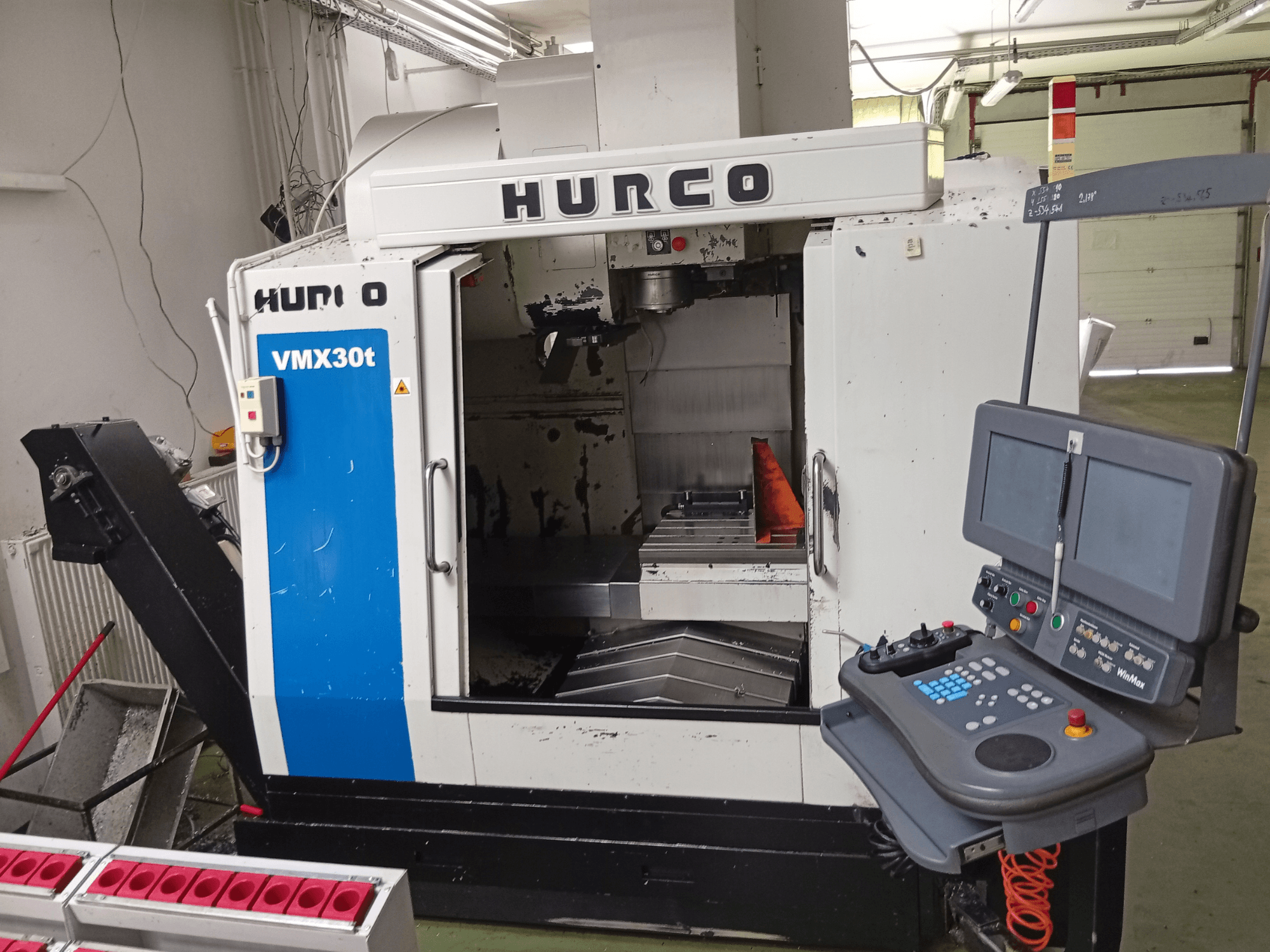Centro di lavoro verticale Hurco VMX 30T, vista frontale, con pannello di comando e zona mandrino, in cui è visibile il piano di lavoro.