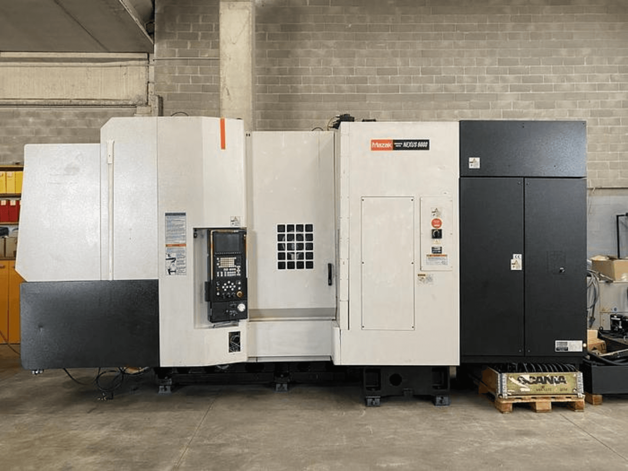 Tornio CNC Mazak NEXUS 6400, vista frontale, con pannello di controllo, interruttore di alimentazione e alloggiamento bicolore bianco e nero.