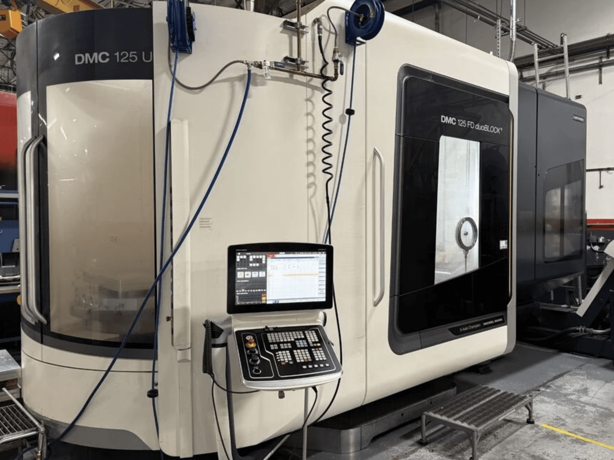 Centro di lavorazione universale DMG MORI DMC 125 U duoBLOCK, vista frontale con pannello di comando e superfici riflettenti.