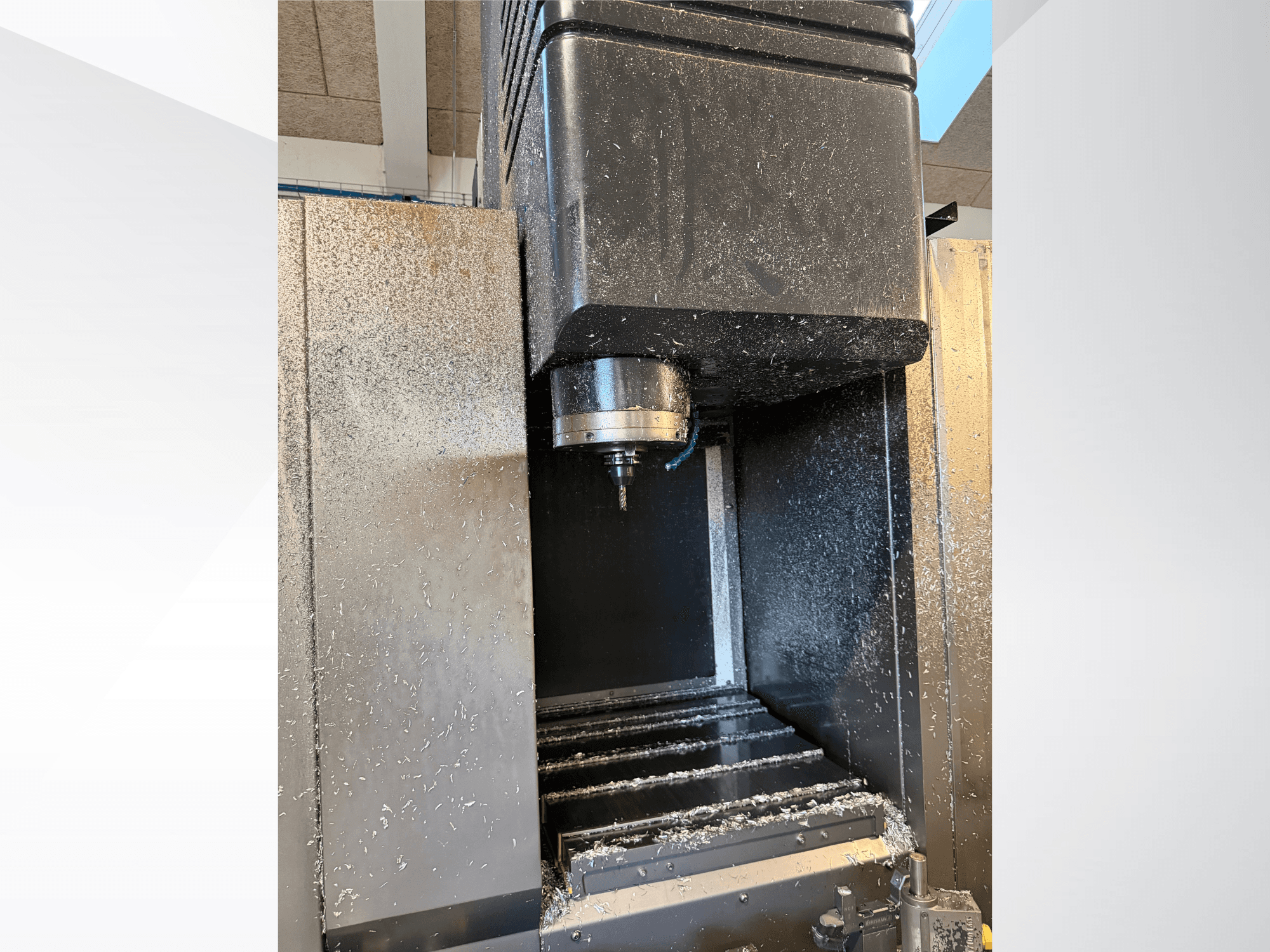Centro di lavorazione verticale Mazak VTC 300C II, vista frontale, con mandrino e trucioli generati dal processo di lavorazione.