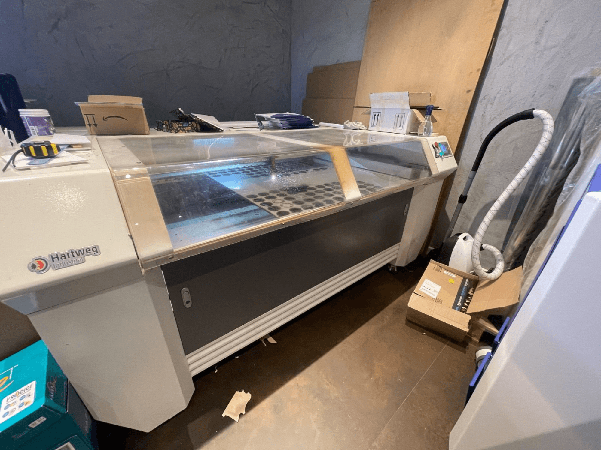 Macchina da taglio laser CO2 Bodor CL-1610XUF in vista laterale, che mostra l'area di lavoro con le fessure per il materiale e il pannello di controllo.