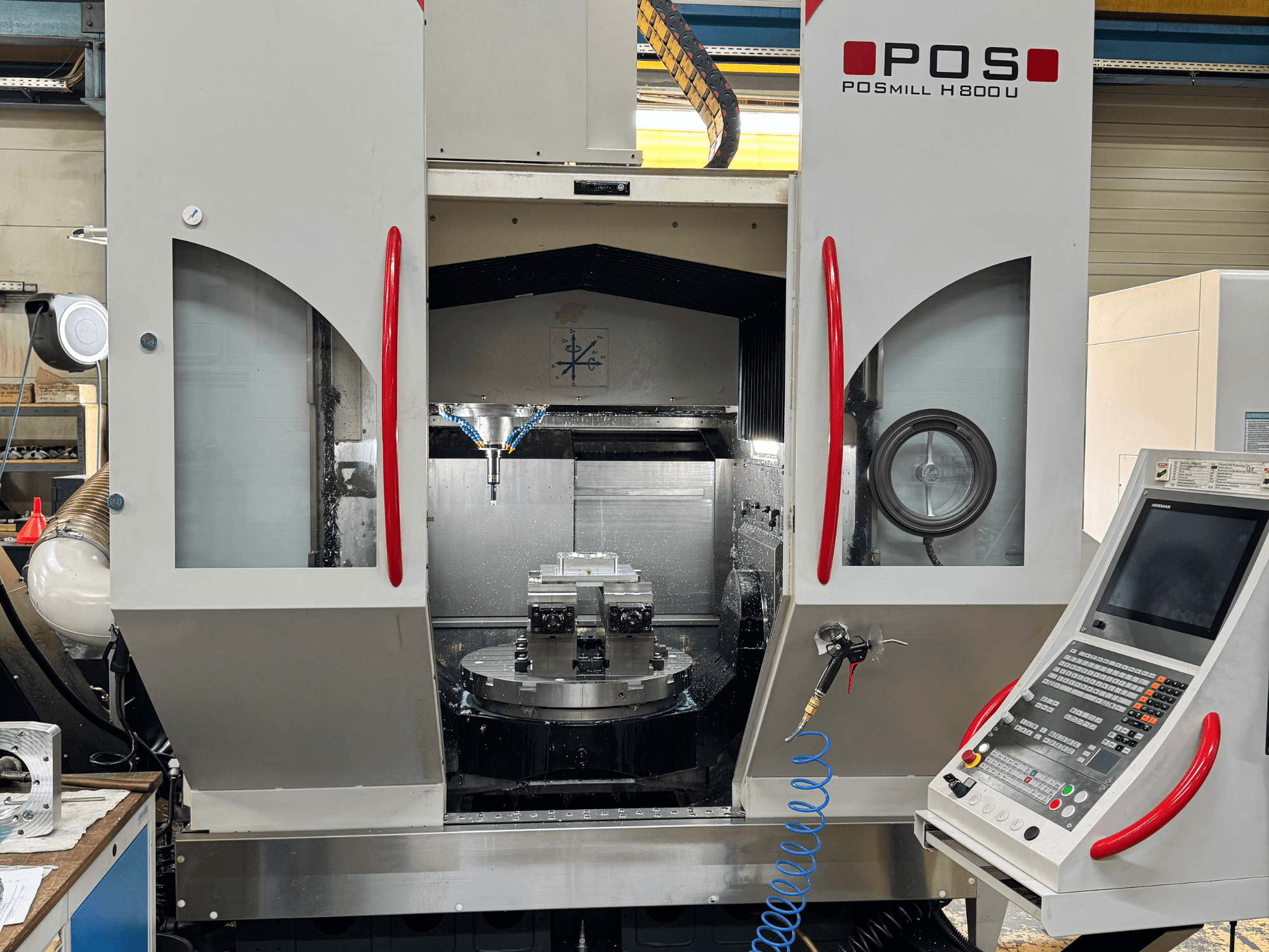 Centro di lavorazione verticale POSmill H 800 U, vista frontale che mostra i componenti interni, il sistema di raffreddamento e il pannello di controllo.