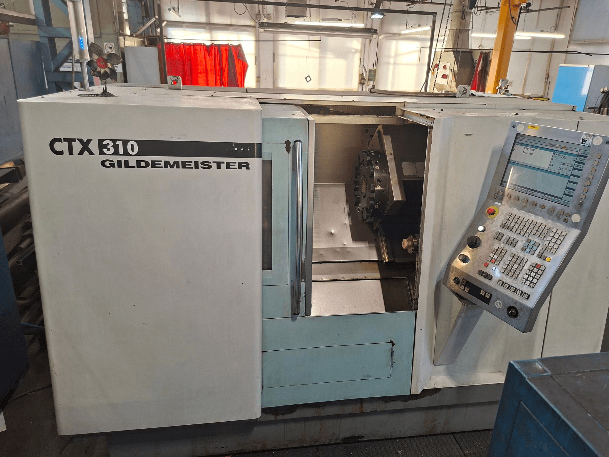Tornio orizzontale DMG CTX 310, vista frontale, con pannello di controllo e accesso aperto all'area di lavoro.