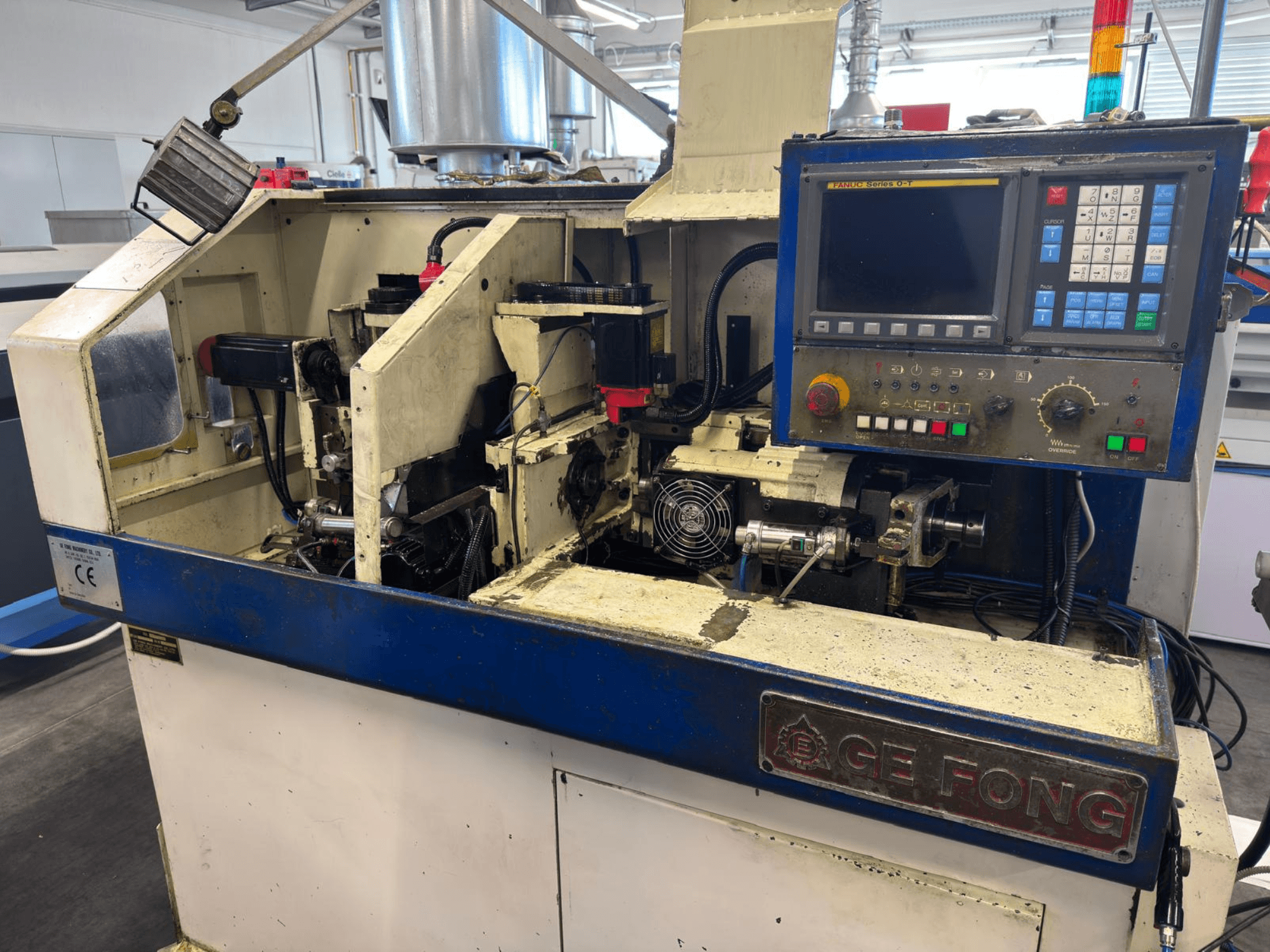 Macchina industriale GE FONG in vista frontale, con componenti interni, pannello di controllo e parti operative.