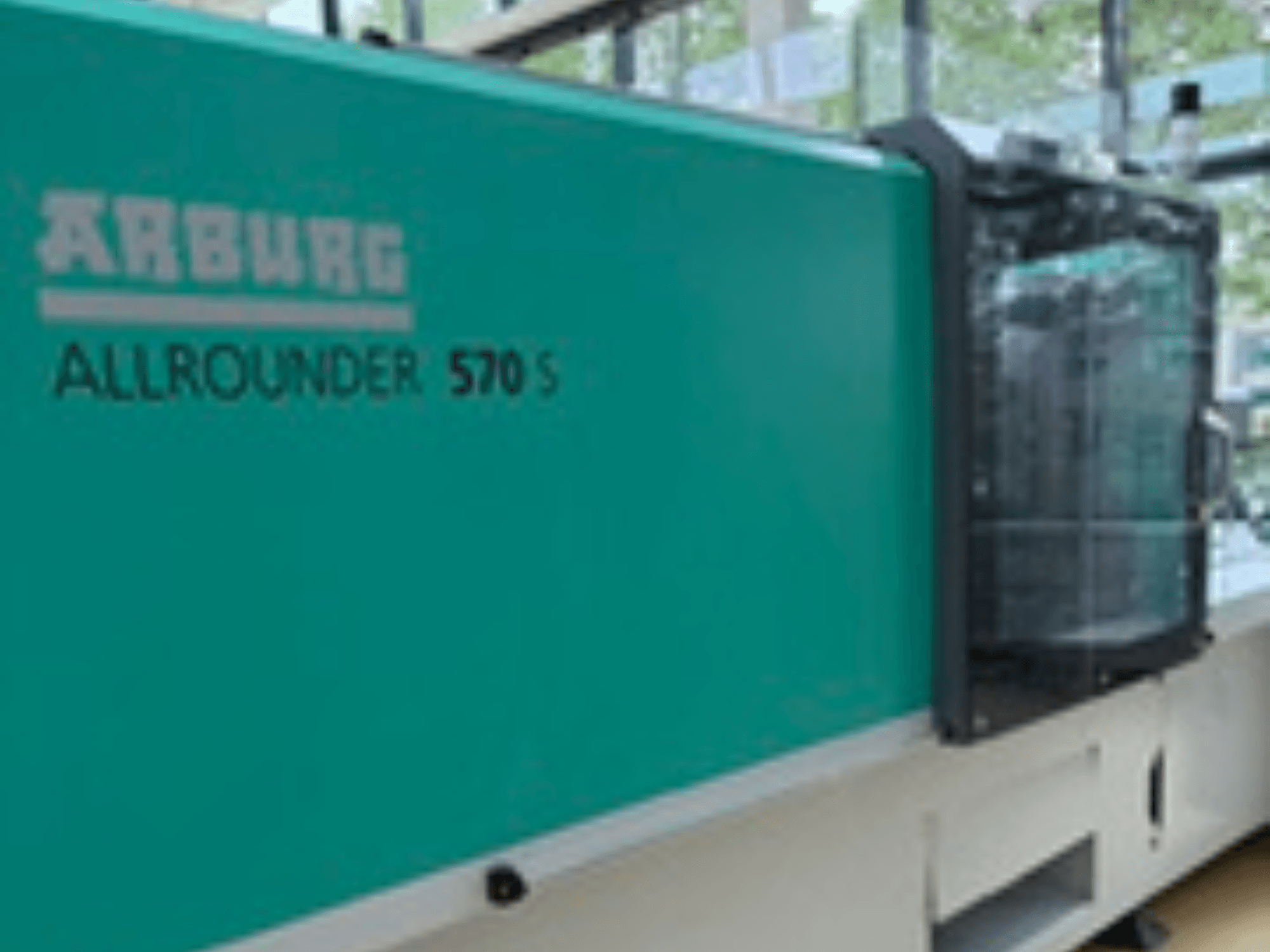 Vista frontale dell'ALLROUNDER 570 S 1600-290 di Arburg, con esterno verde acqua e gruppo di iniezione, che mostra parte del design della macchina.